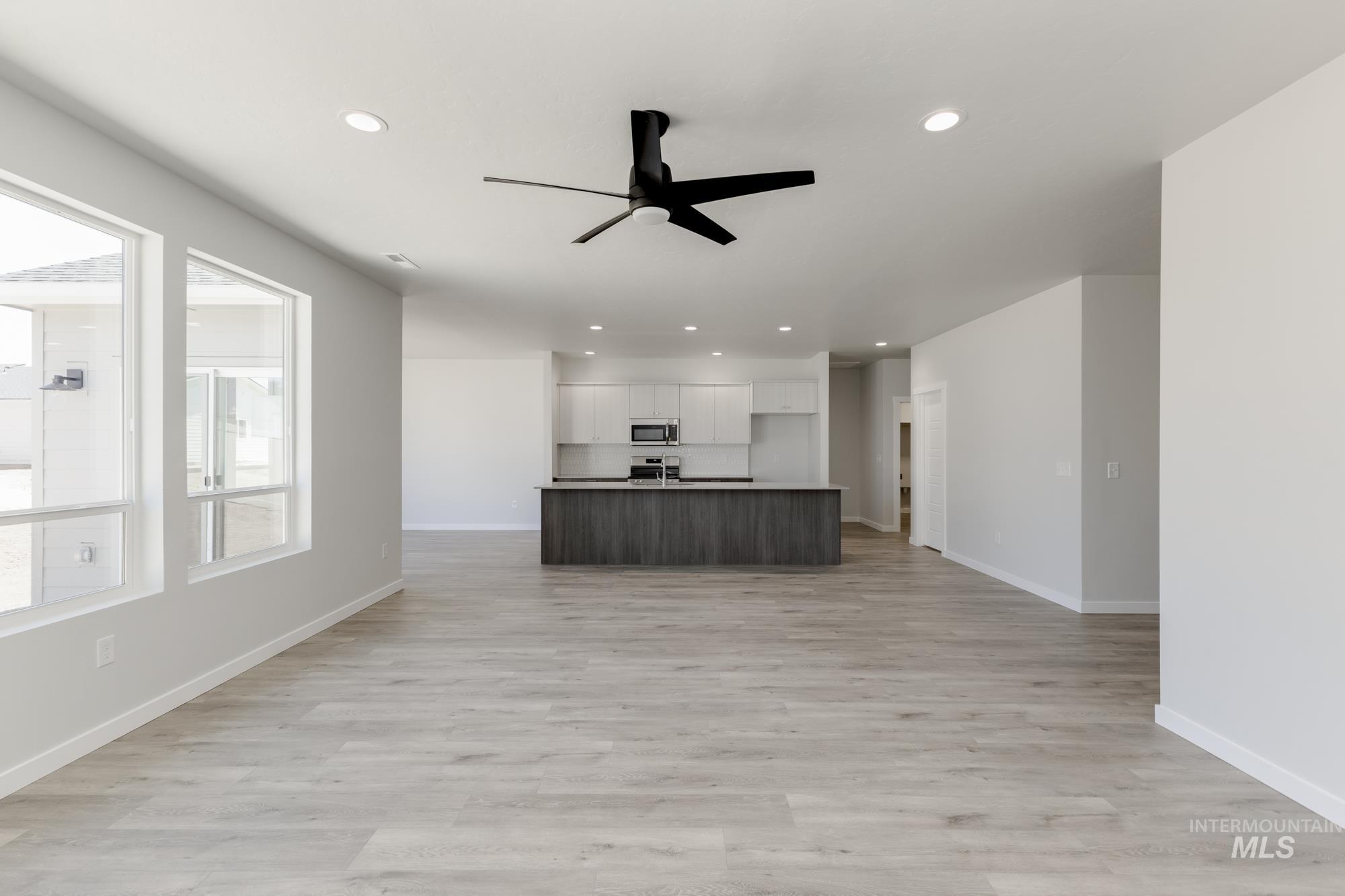 Unfurnished living room with ceiling fan, recessed lighting, and light wood-style floors