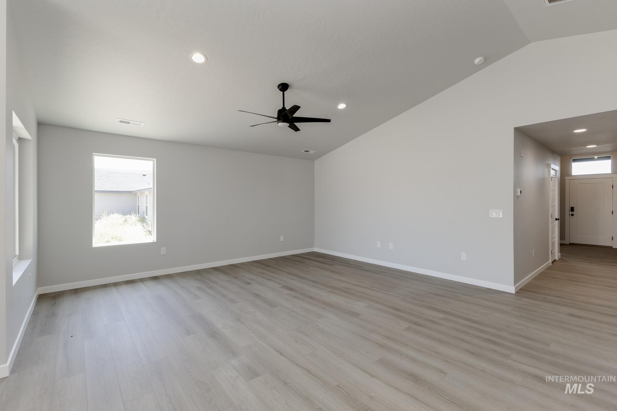 Unfurnished room with lofted ceiling, ceiling fan, light wood-style floors, and recessed lighting