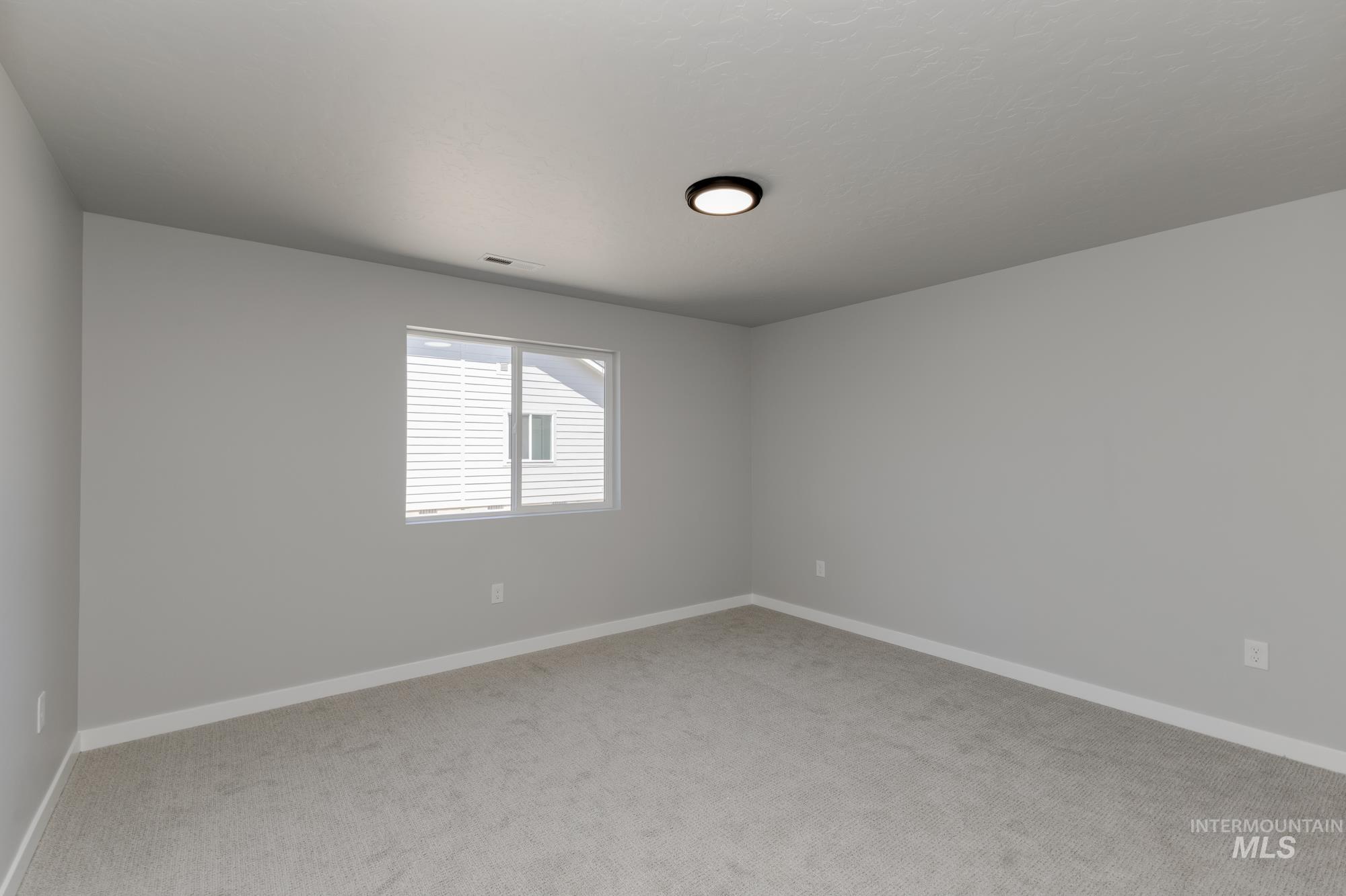 Carpeted spare room with baseboards