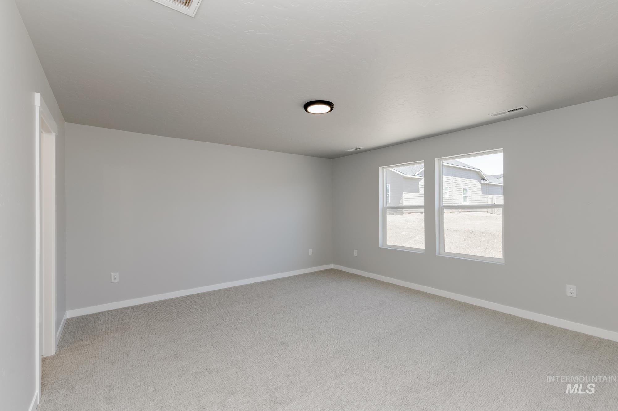 Empty room featuring light colored carpet