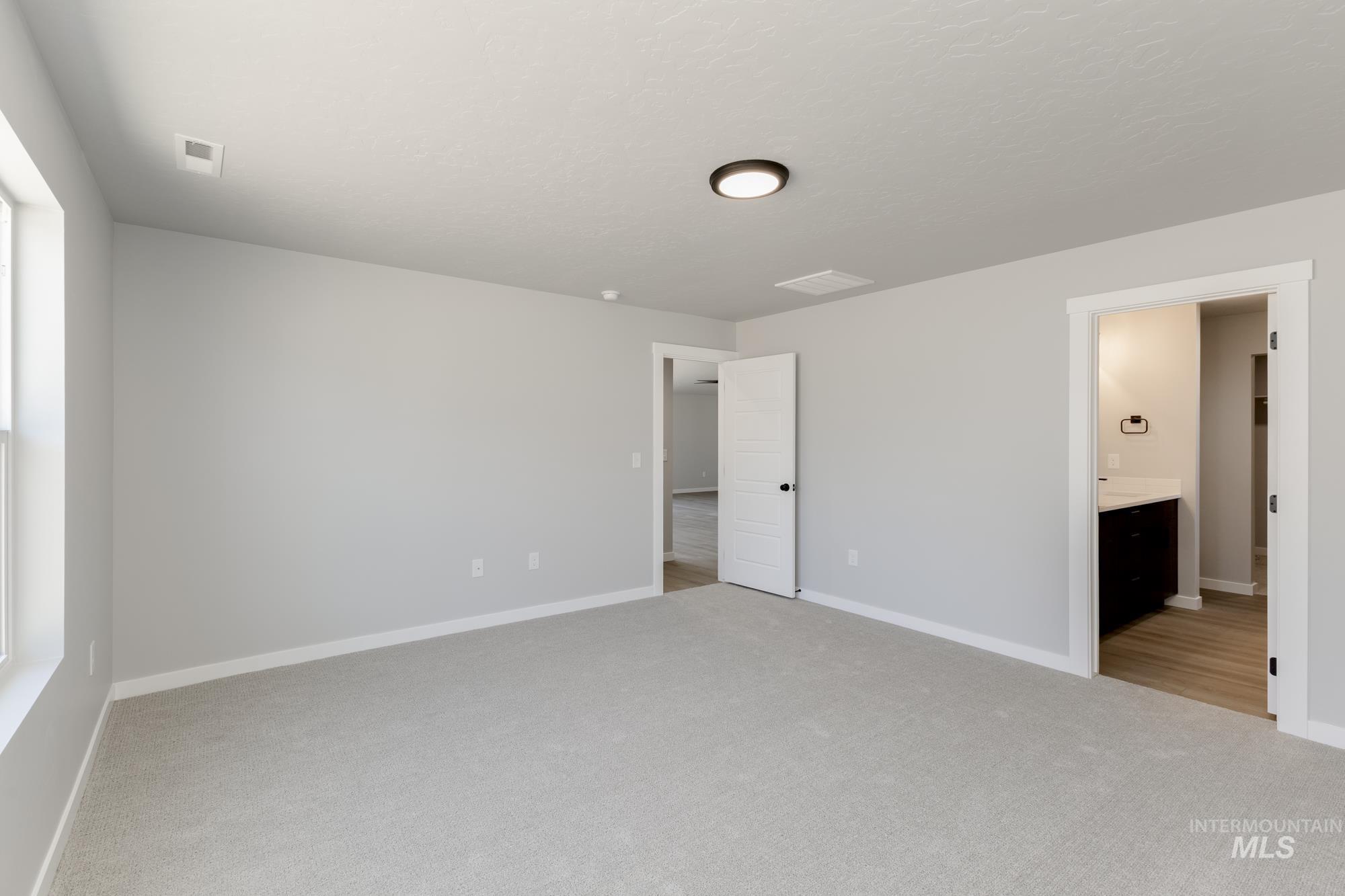 Unfurnished bedroom with carpet flooring and ensuite bath