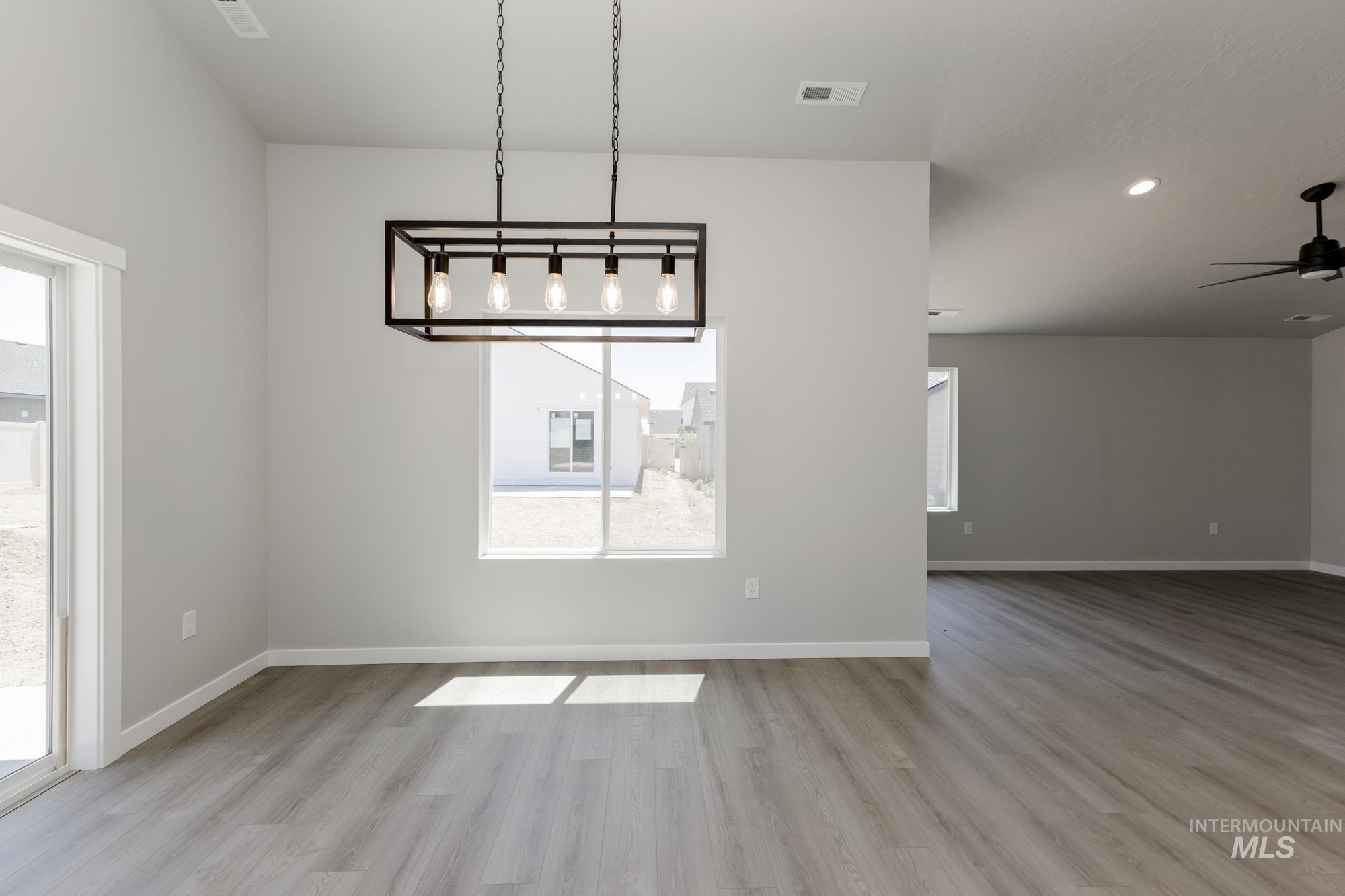 Unfurnished dining area with wood finished floors, healthy amount of natural light, ceiling fan, and recessed lighting