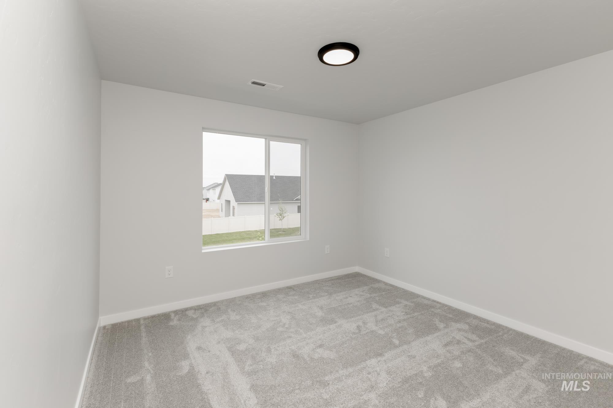 Carpeted empty room with baseboards