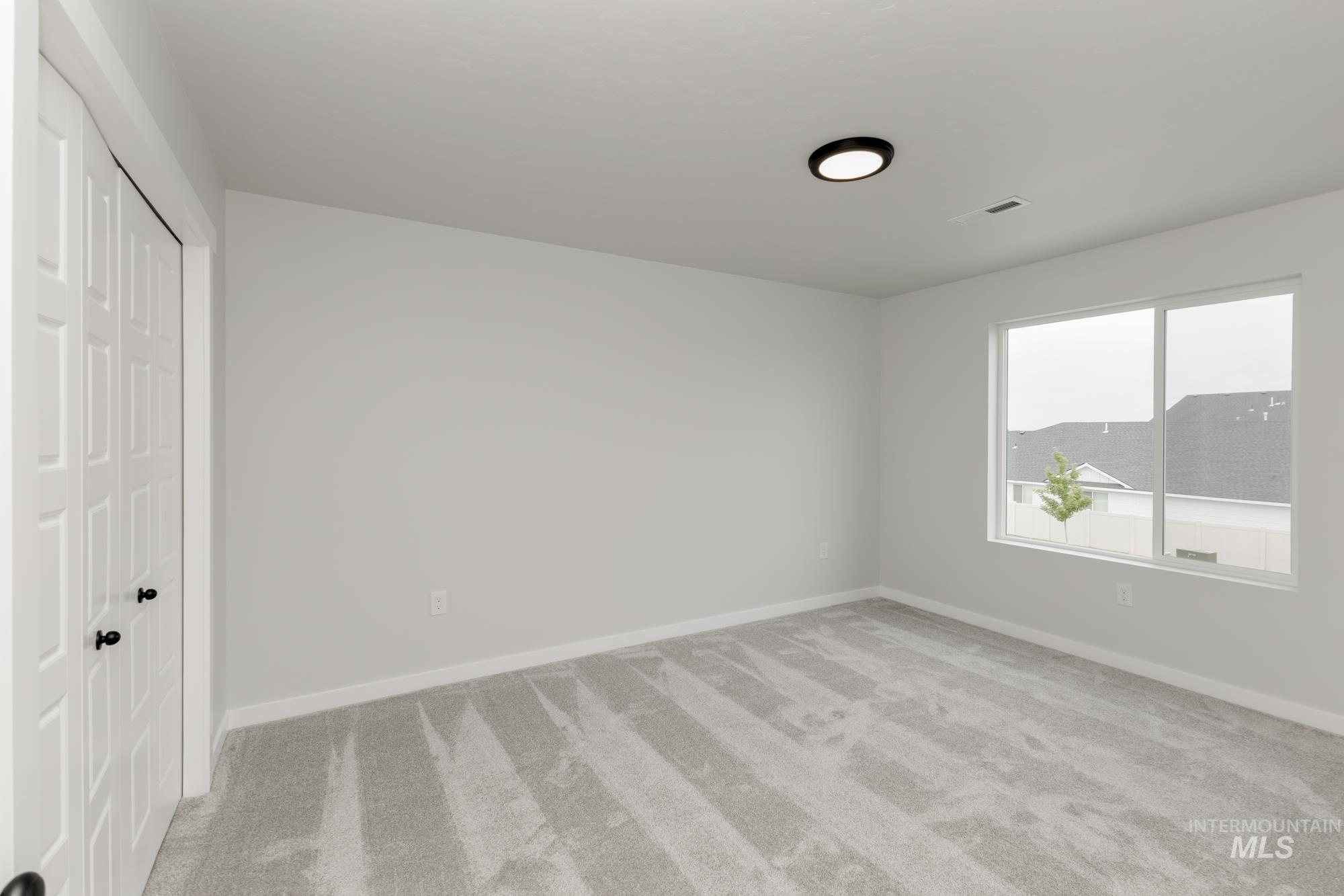 Unfurnished bedroom featuring light colored carpet and a closet