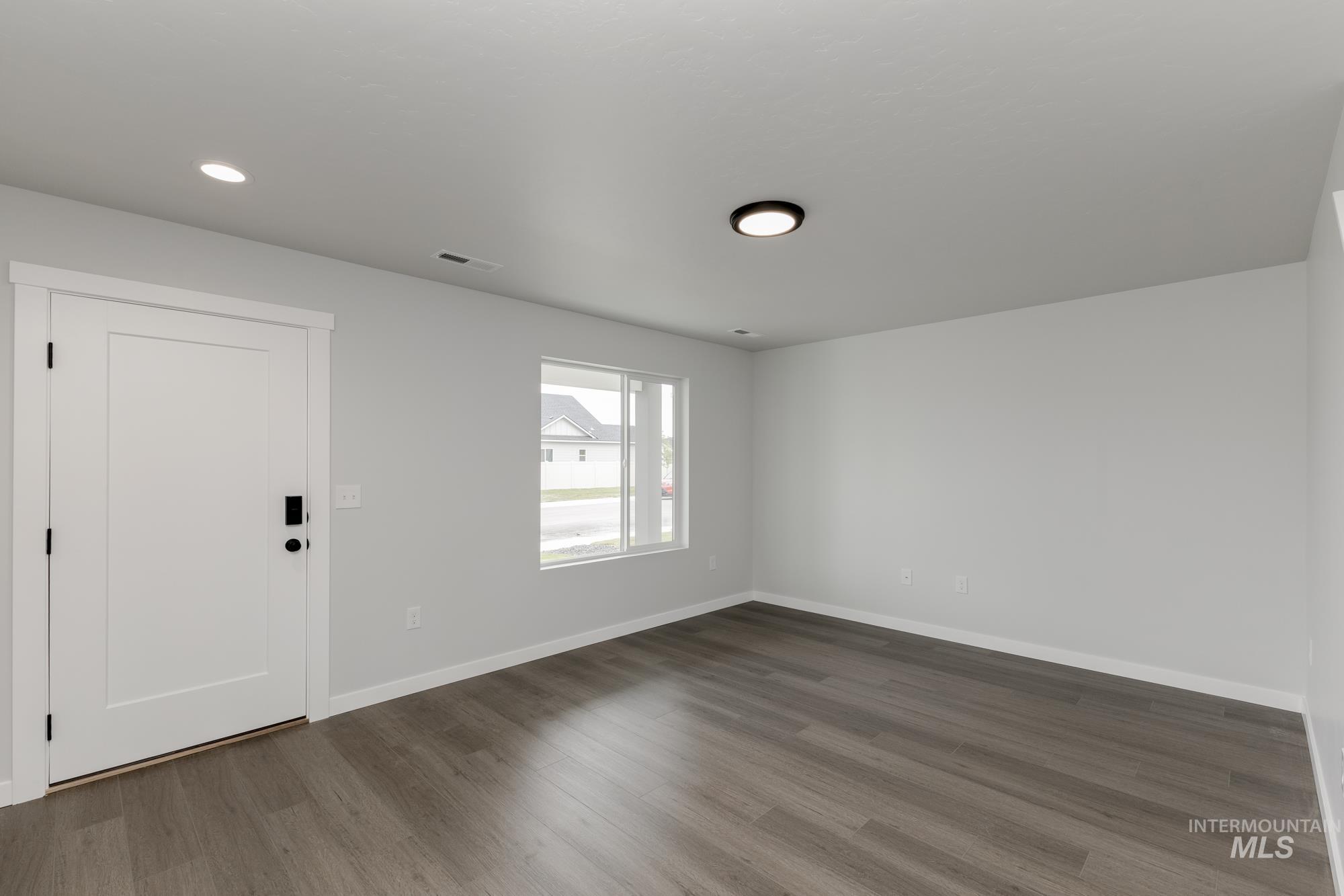 Spare room featuring dark wood finished floors and recessed lighting