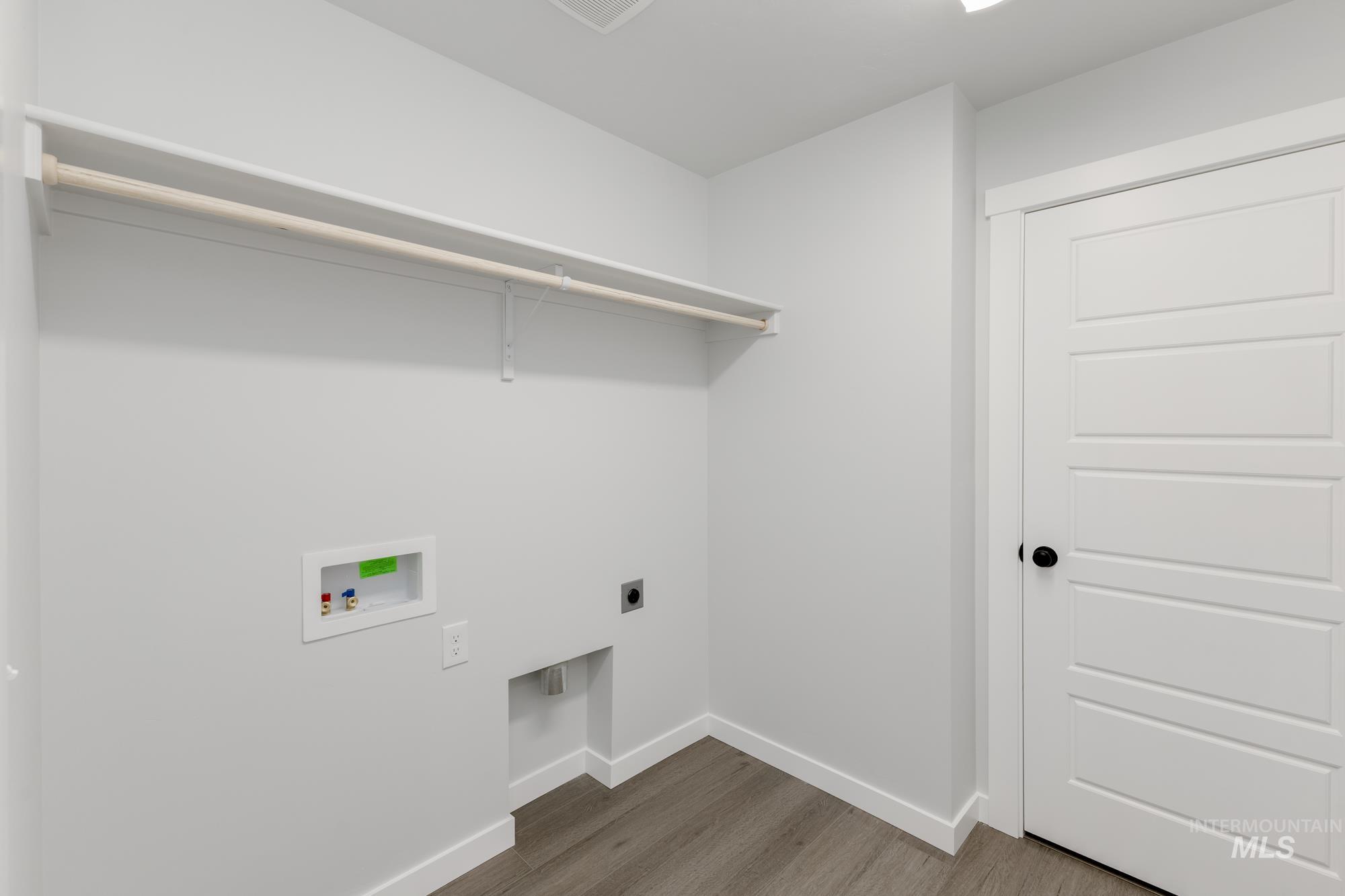 Laundry room with hookup for an electric dryer, hookup for a washing machine, and wood finished floors