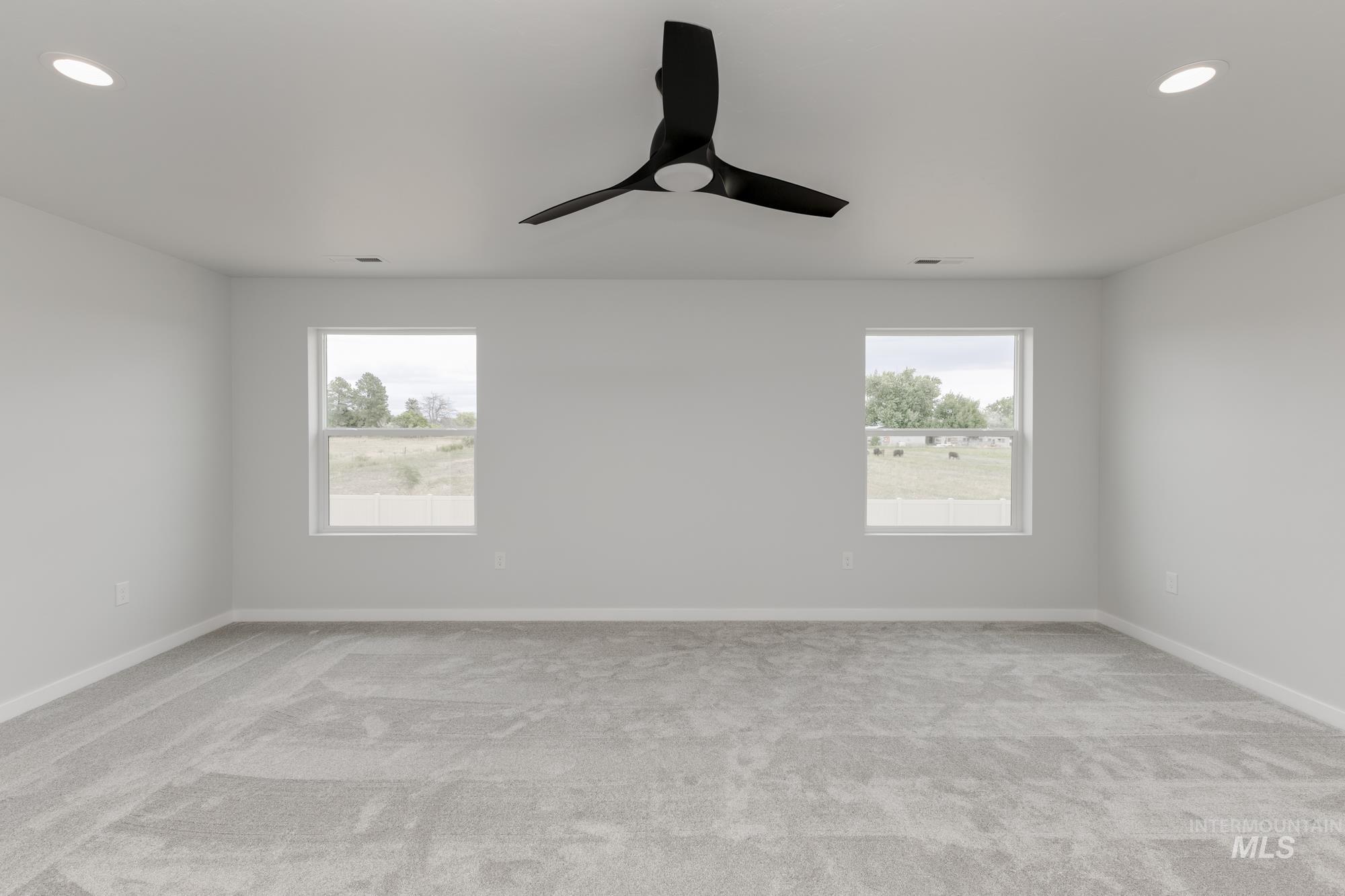 Spare room with ceiling fan, healthy amount of natural light, light colored carpet, and recessed lighting