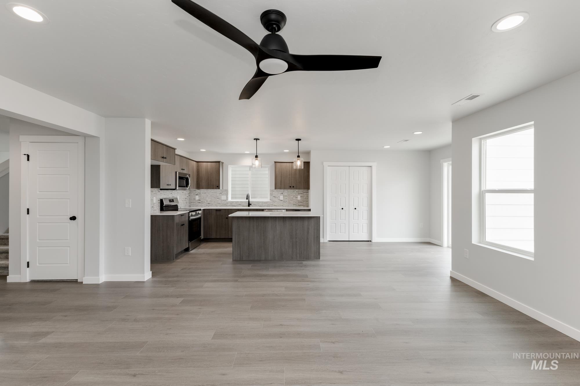 Kitchen with stainless steel appliances, open floor plan, a ceiling fan, recessed lighting, and a kitchen island