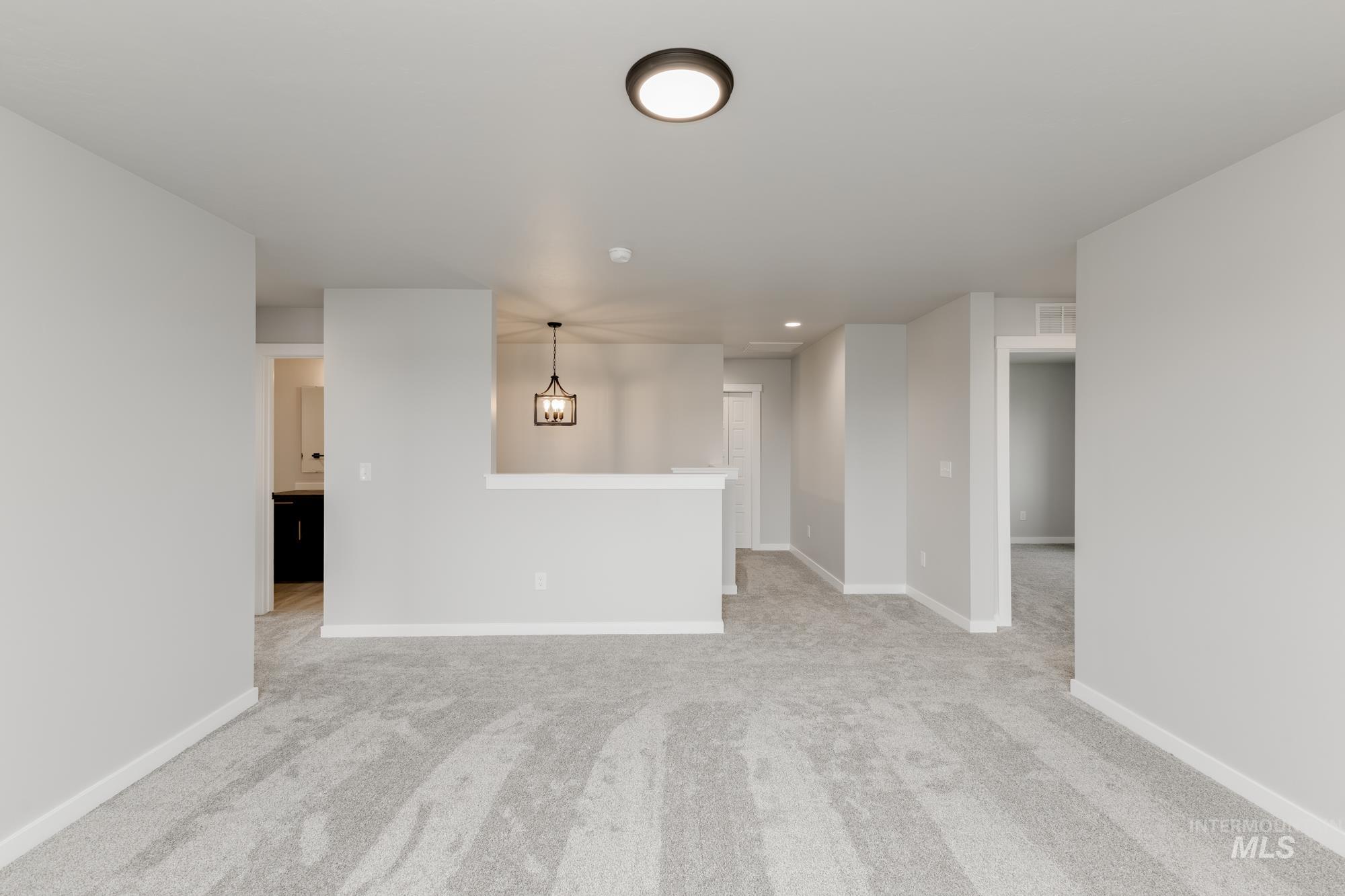 Unfurnished living room featuring light colored carpet and recessed lighting