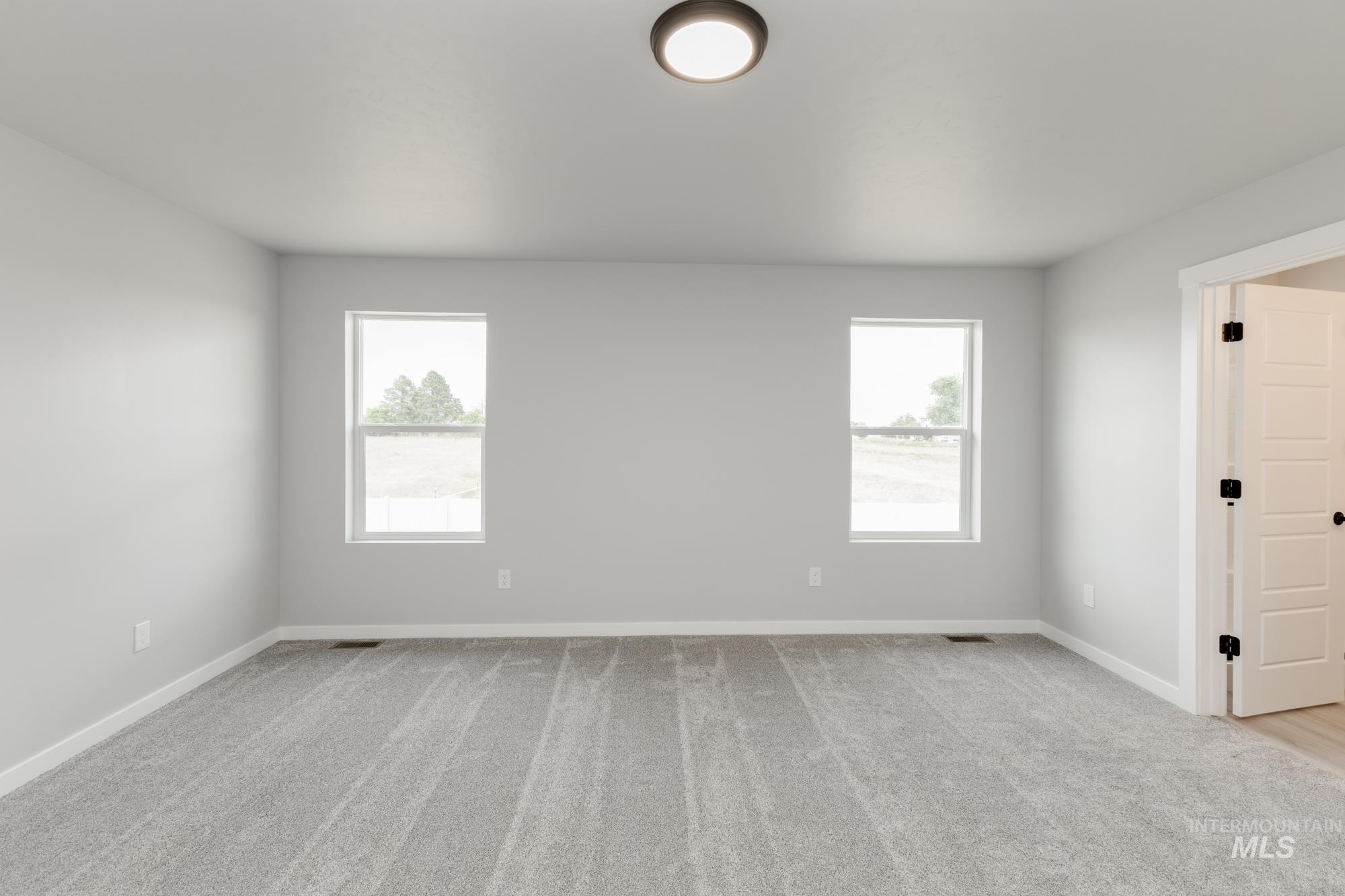 Carpeted spare room with baseboards
