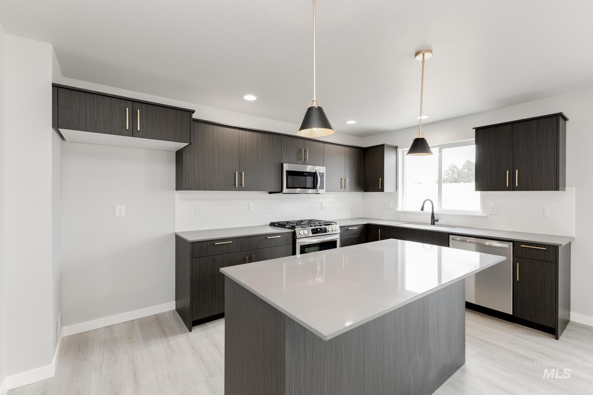 Kitchen featuring stainless steel appliances, tasteful backsplash, light wood finished floors, and recessed lighting