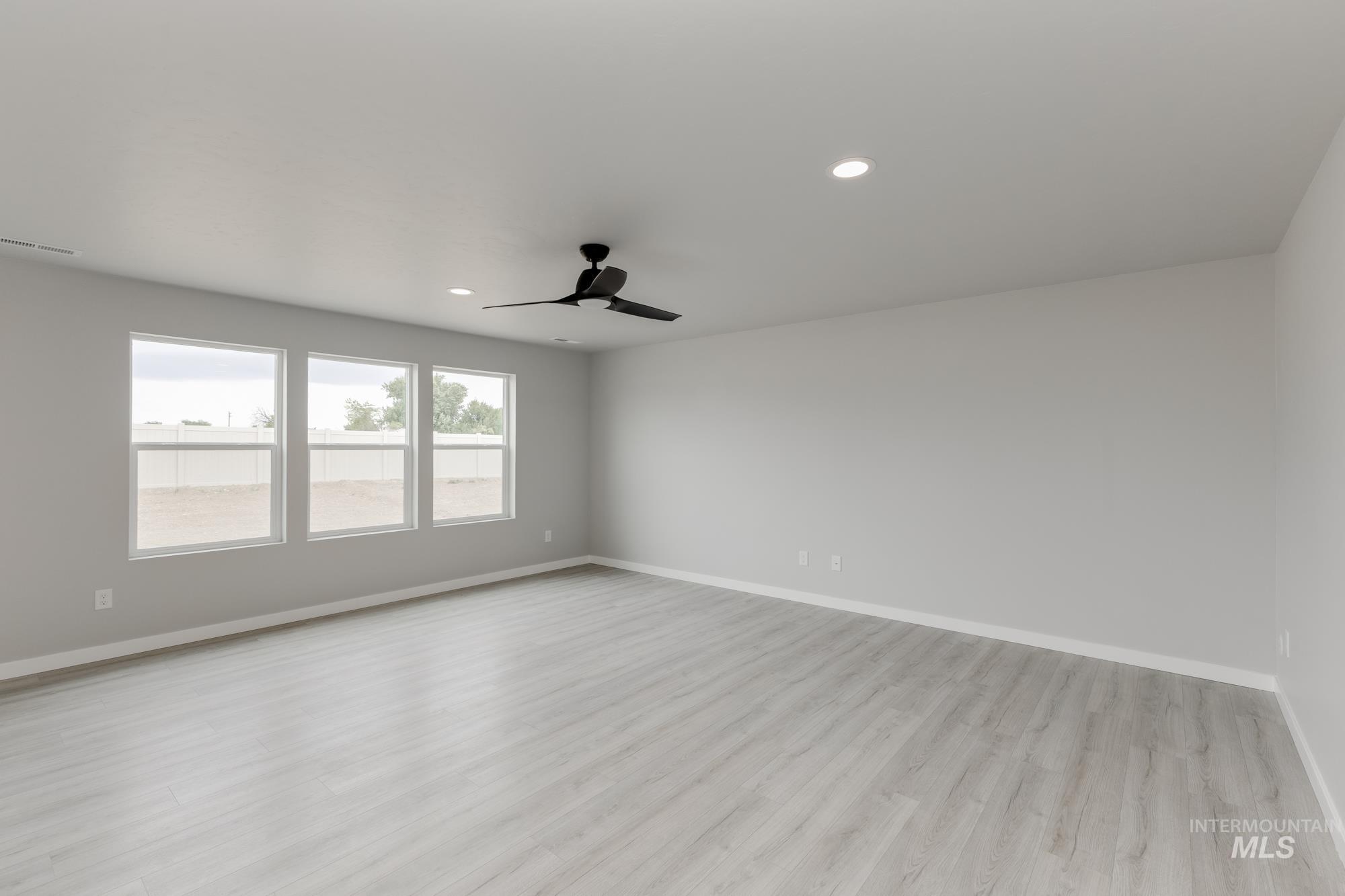 Unfurnished room featuring light wood-style flooring, a ceiling fan, and recessed lighting