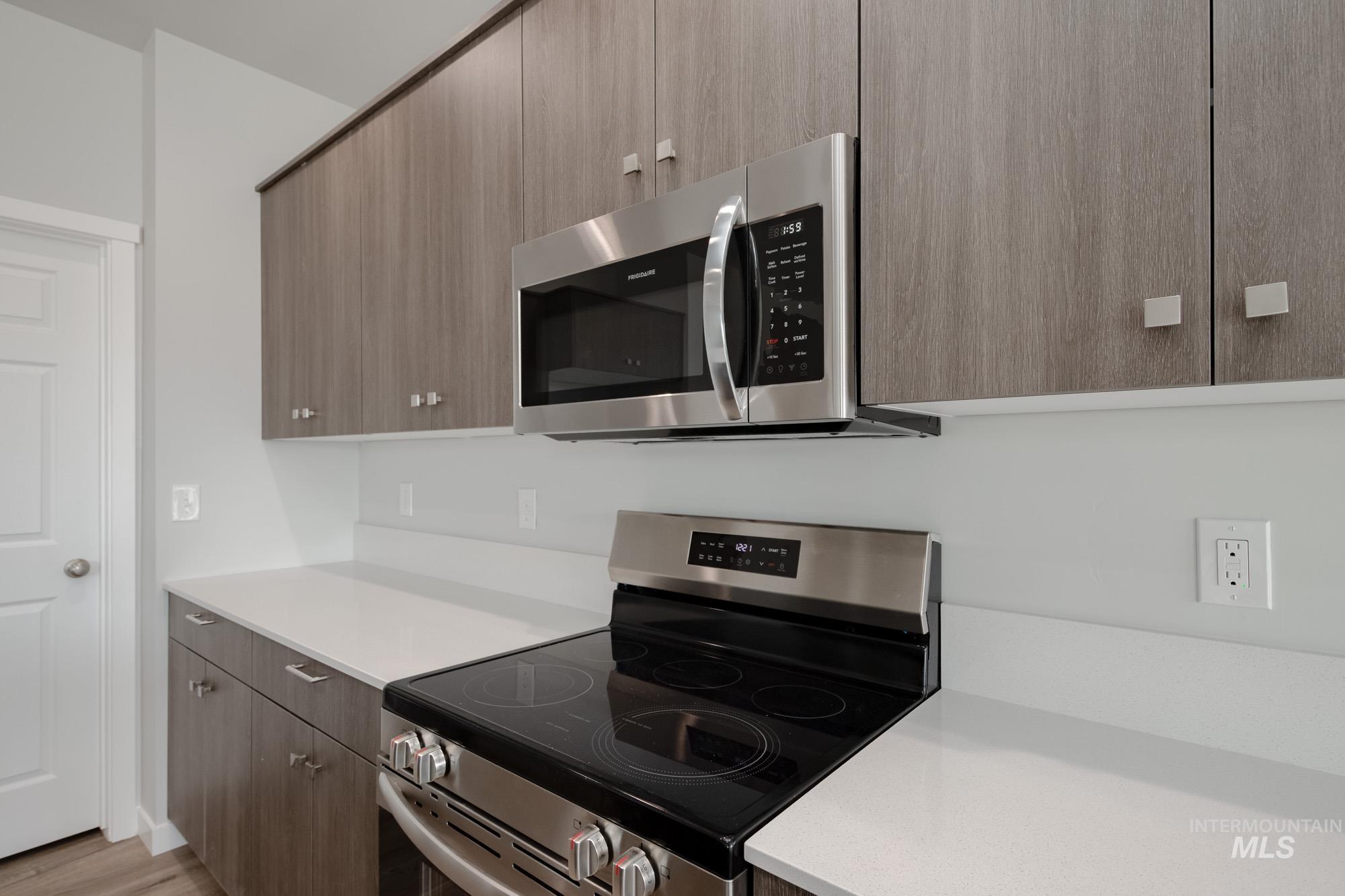 Kitchen with appliances with stainless steel finishes, light countertops, modern cabinets, and light wood-style flooring