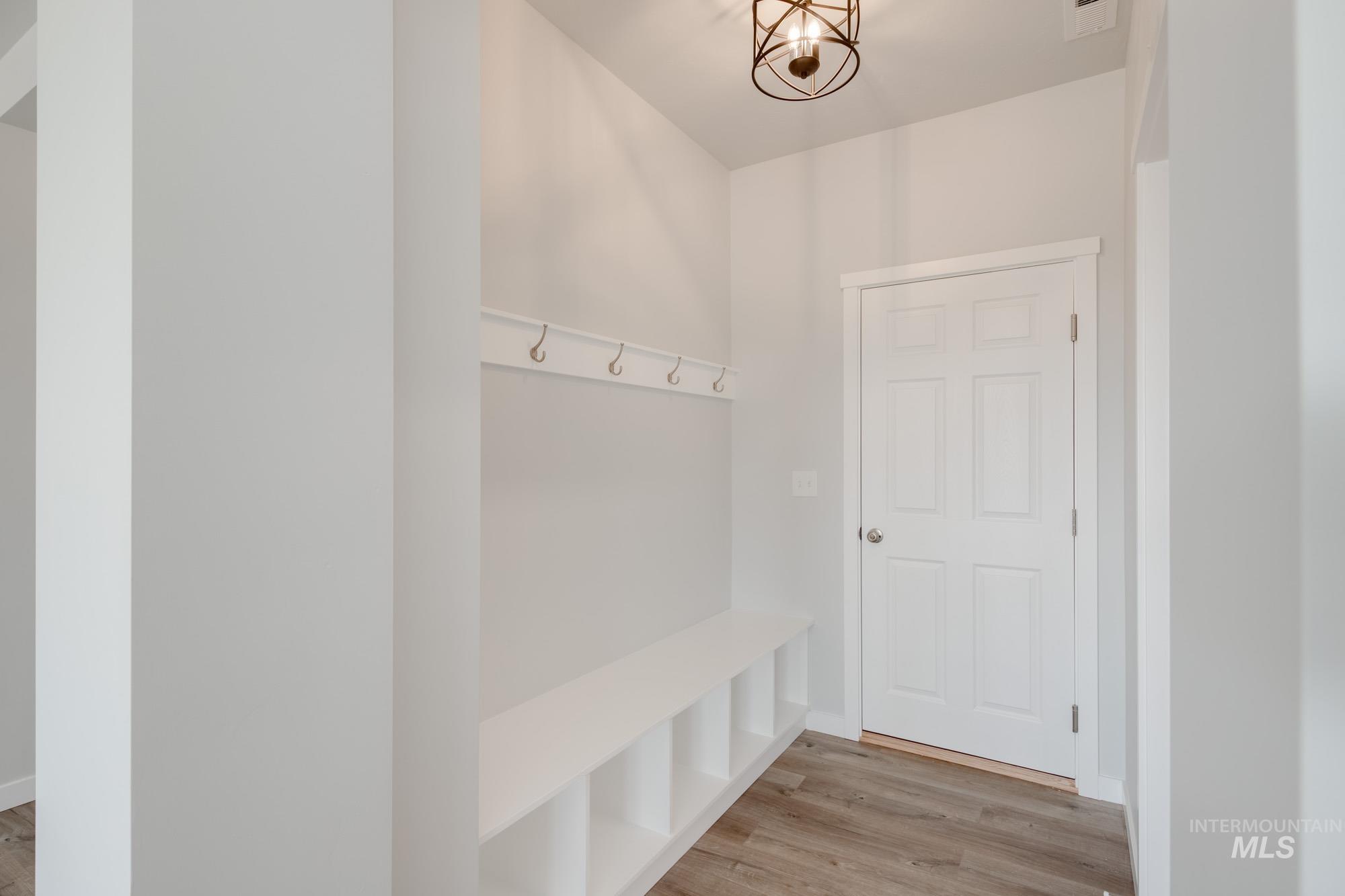 Mudroom featuring light wood-type flooring and a chandelier