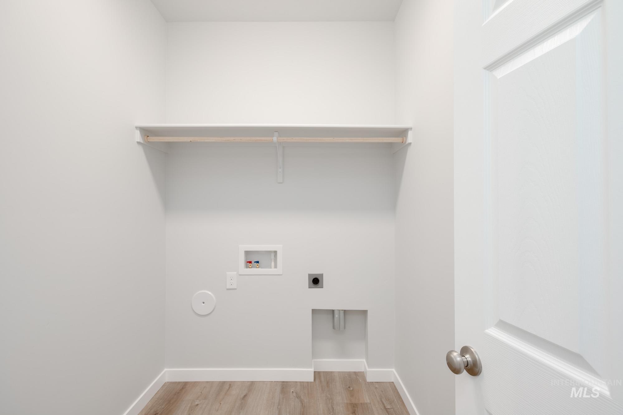 Washroom with light wood-style floors, hookup for an electric dryer, and washer hookup