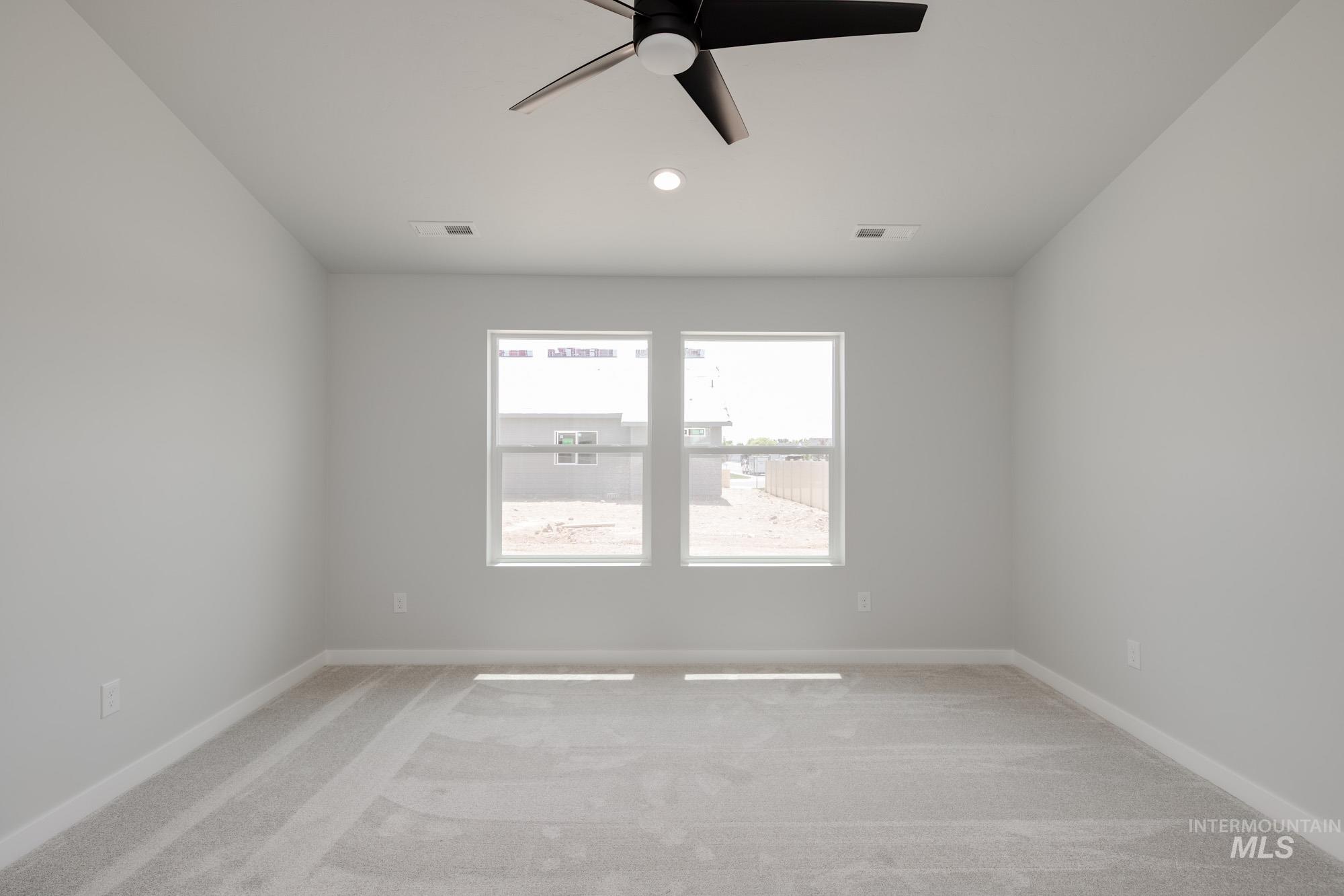 Empty room featuring a ceiling fan, light colored carpet, and recessed lighting