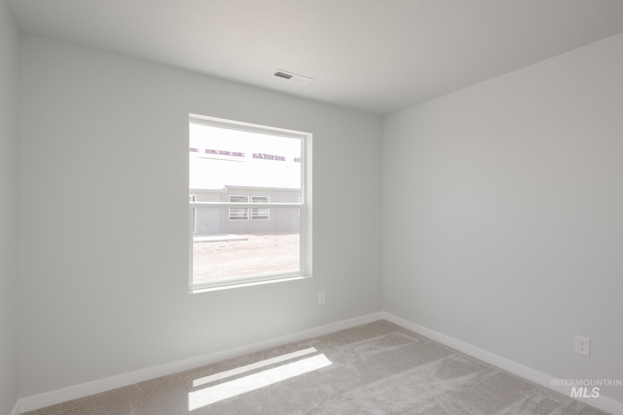 Carpeted empty room featuring baseboards