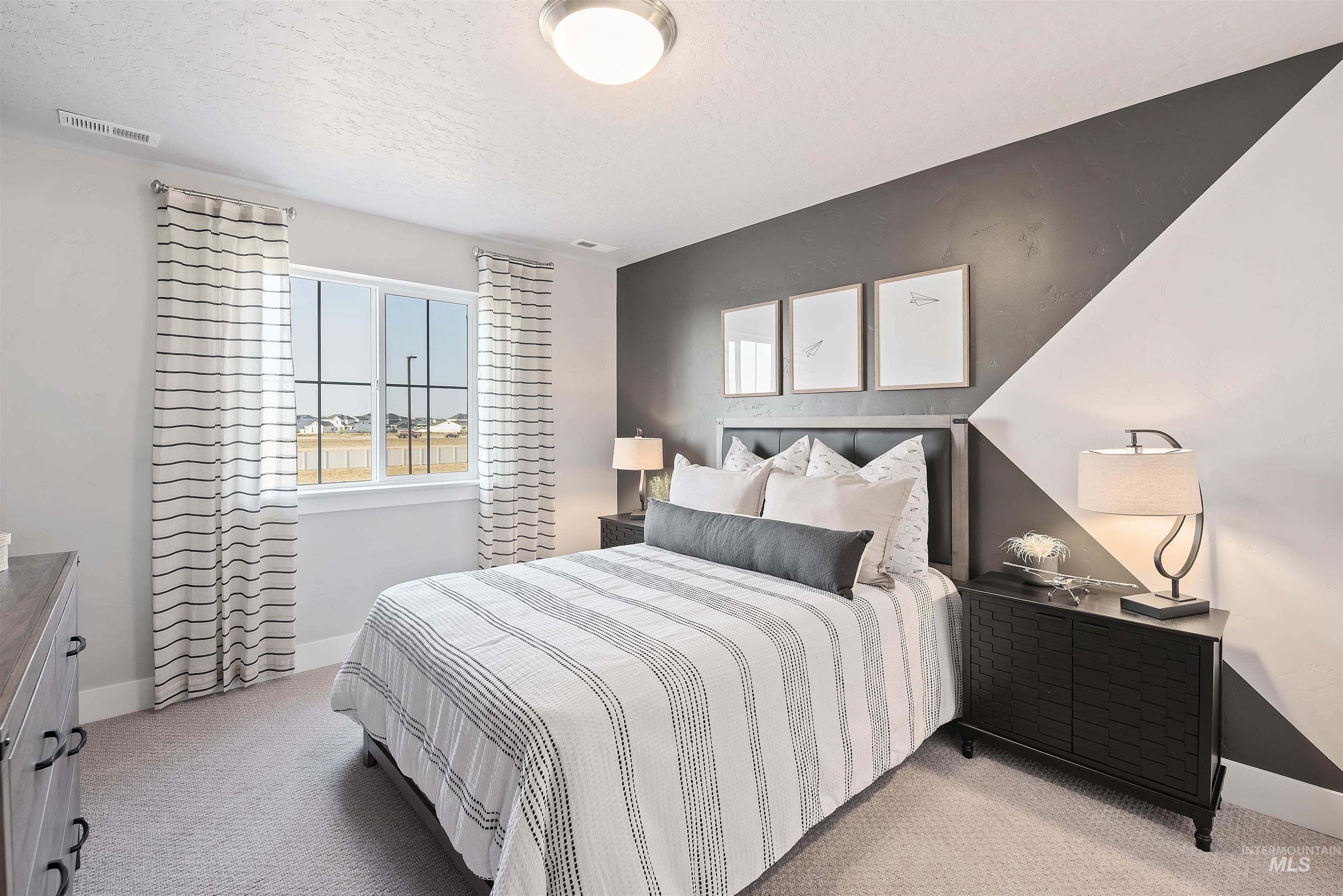 Bedroom with light carpet and a textured ceiling