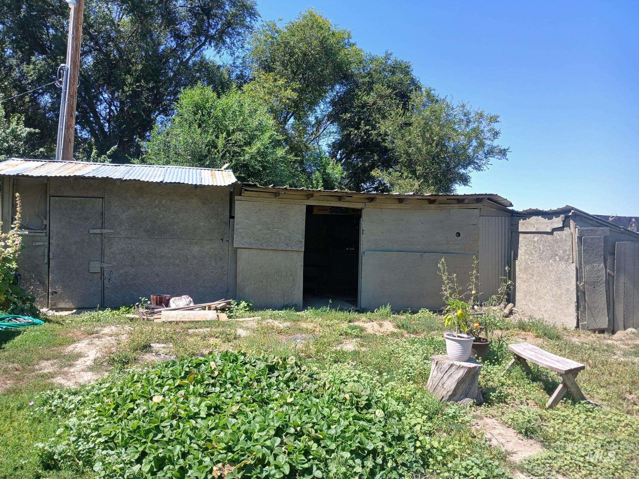 Back of house featuring a metal roof and a shed
