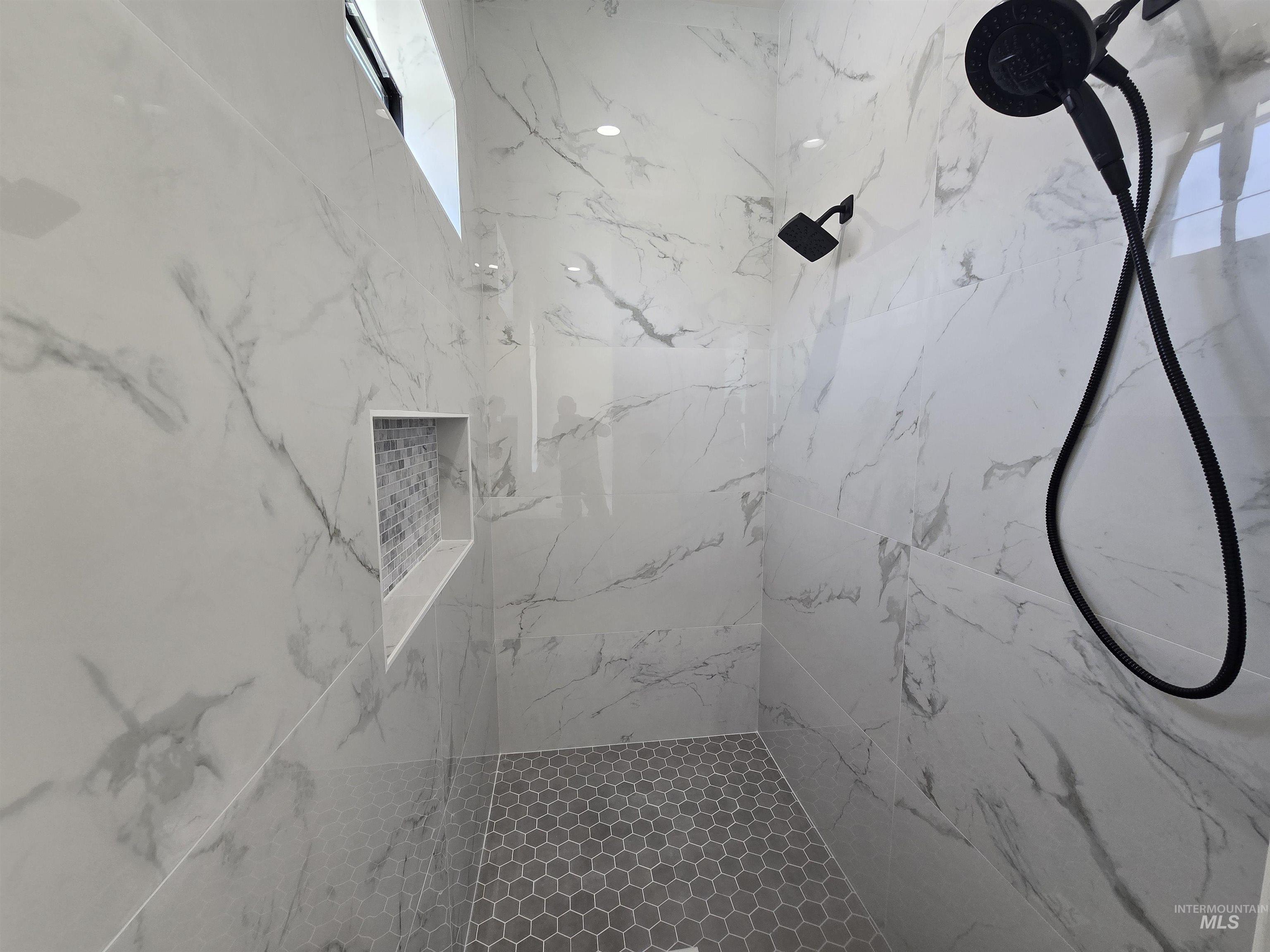 Bathroom featuring a marble finish shower