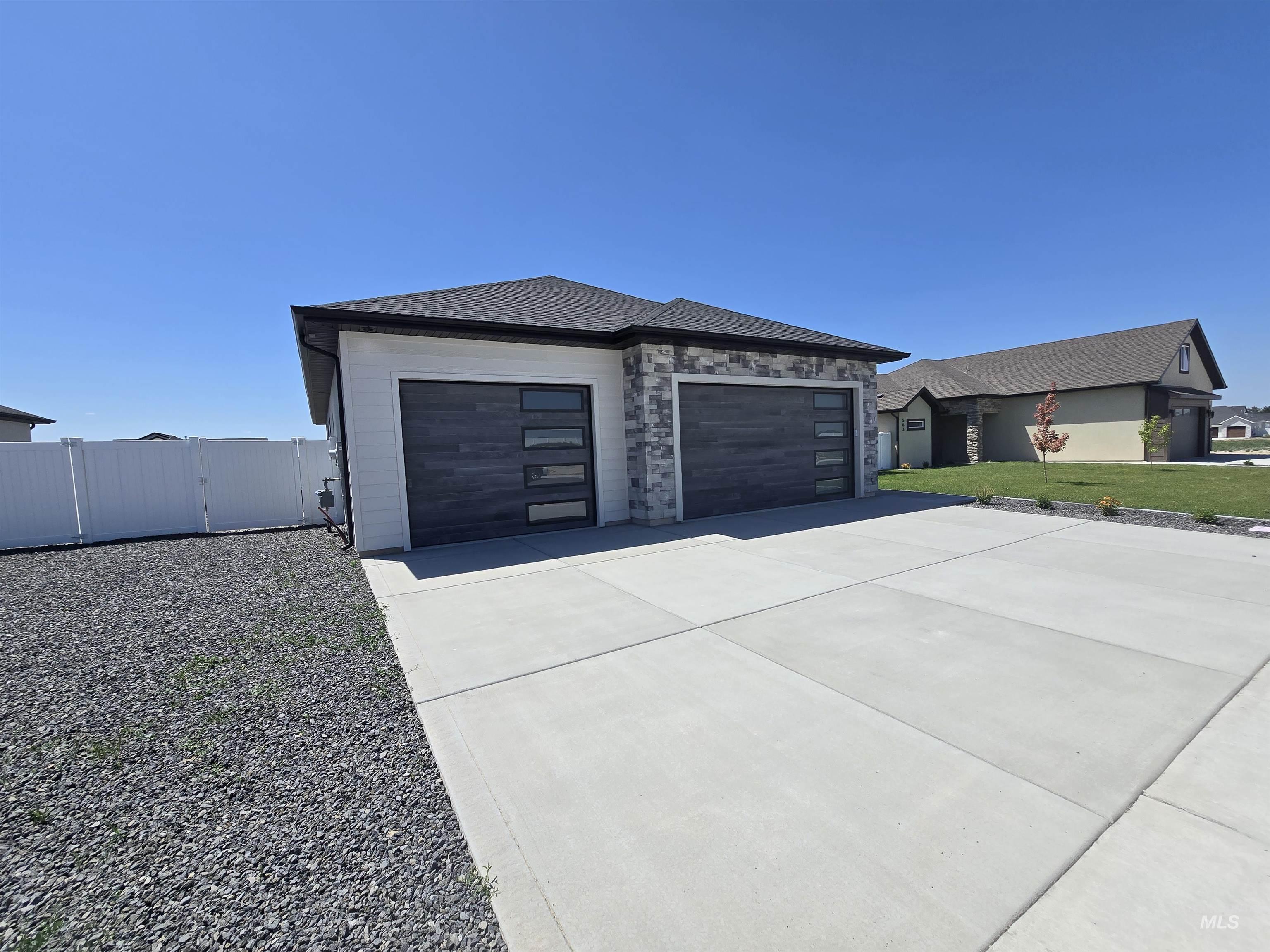 View of front facade featuring a garage and concrete driveway