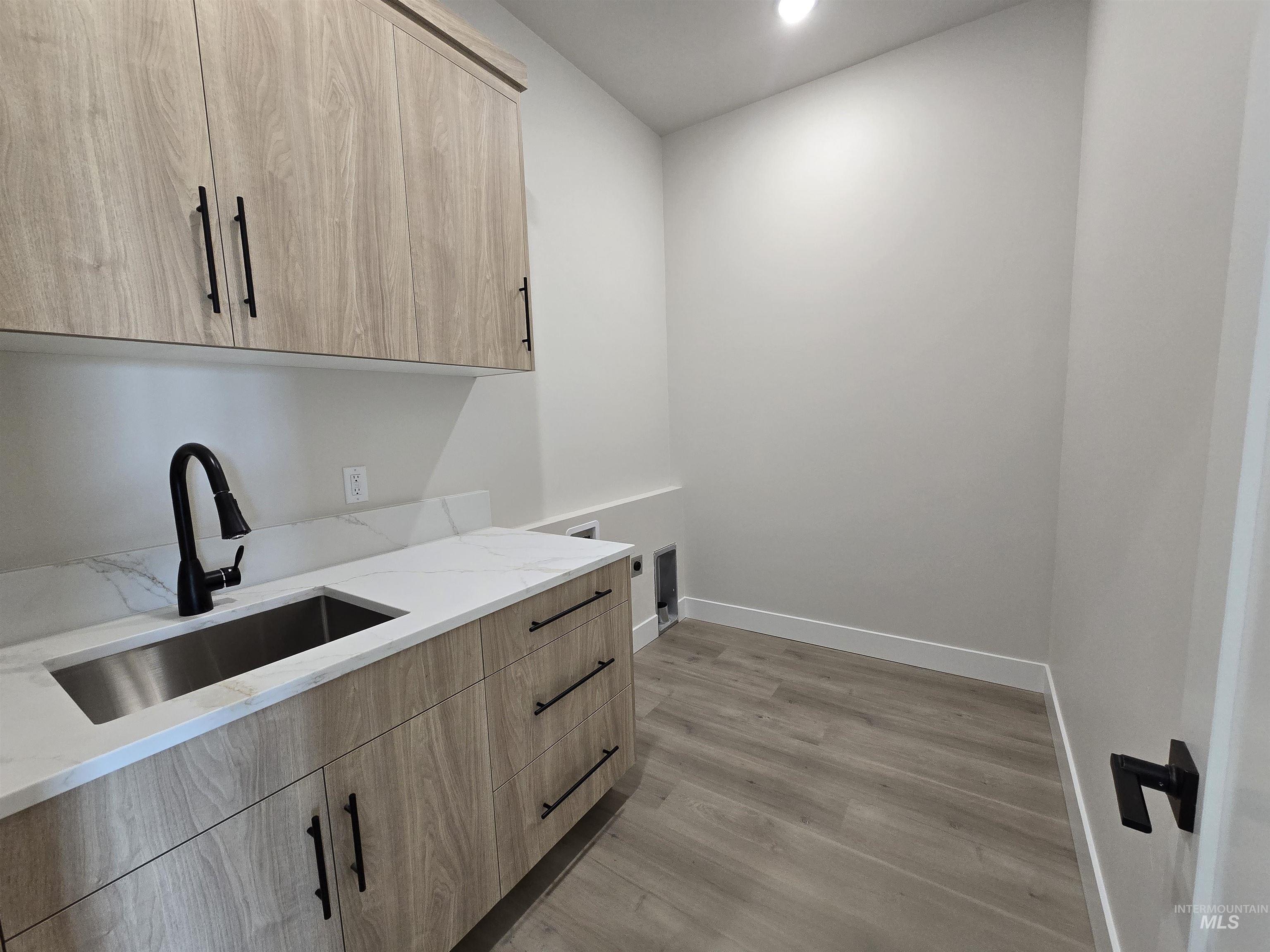 Washroom with cabinet space, light wood-type flooring, and recessed lighting