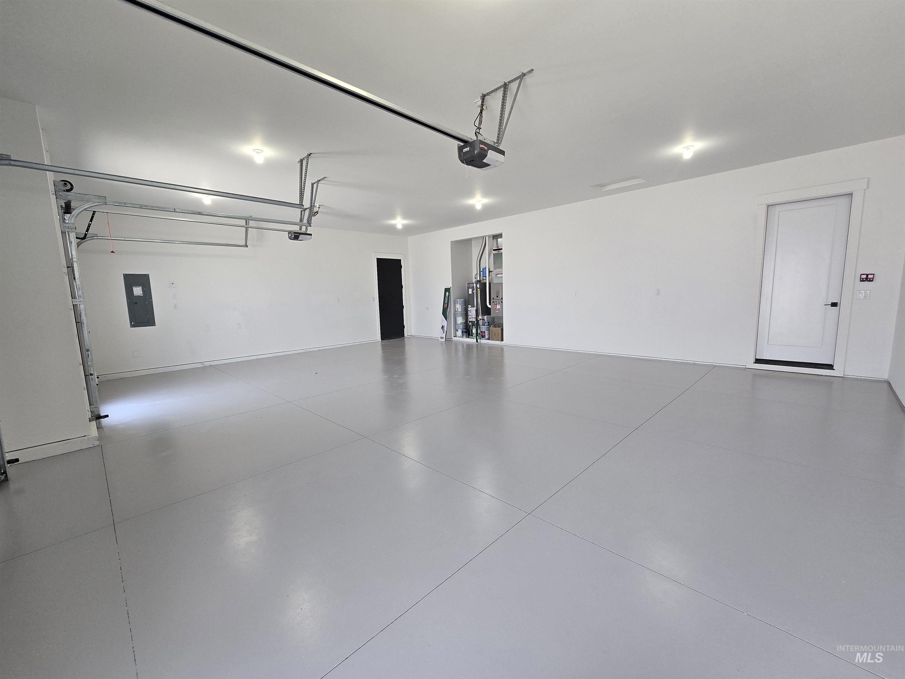 Garage featuring a garage door opener and electric panel