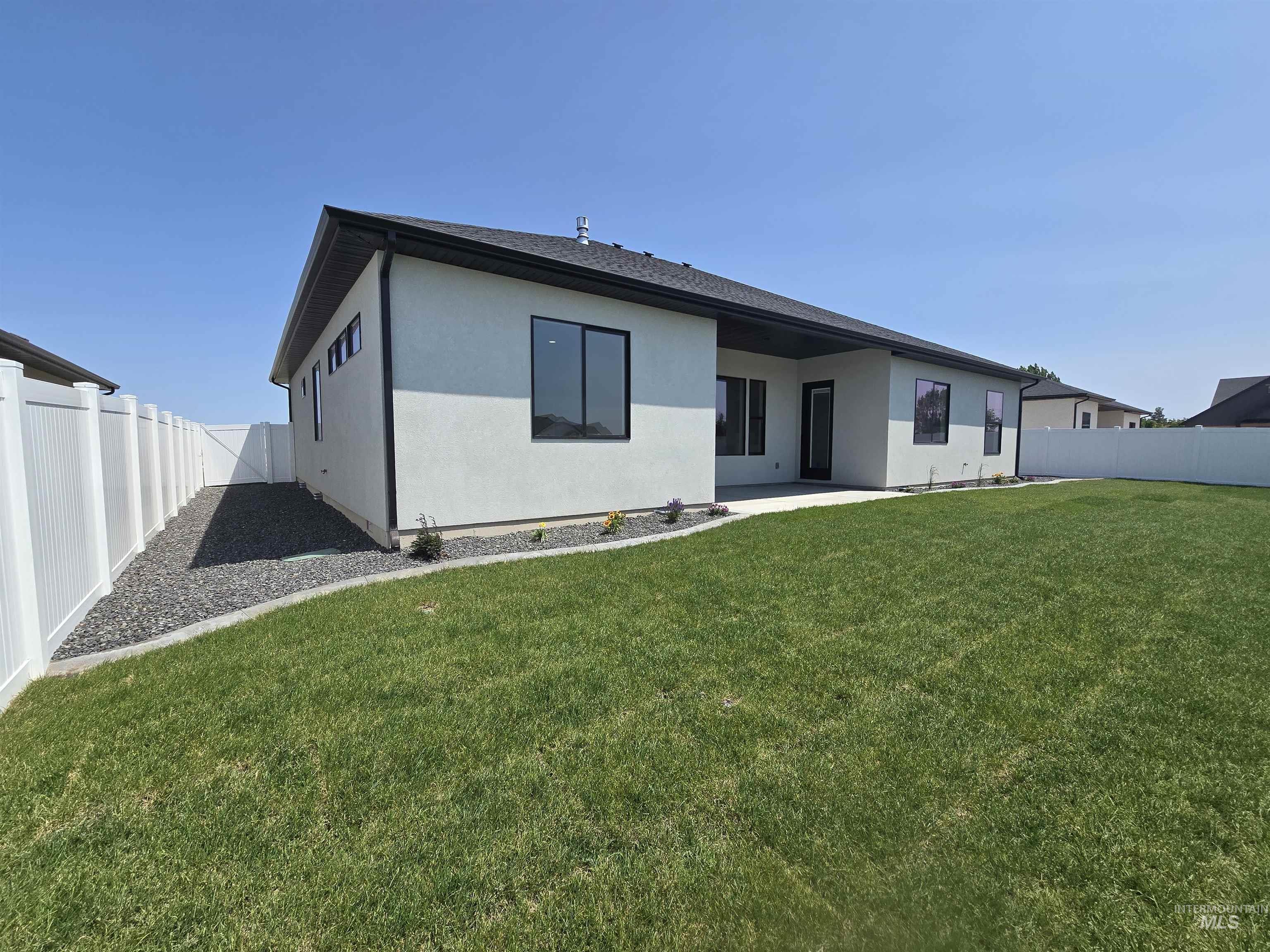 Back of house featuring stucco siding, a fenced backyard, and a patio