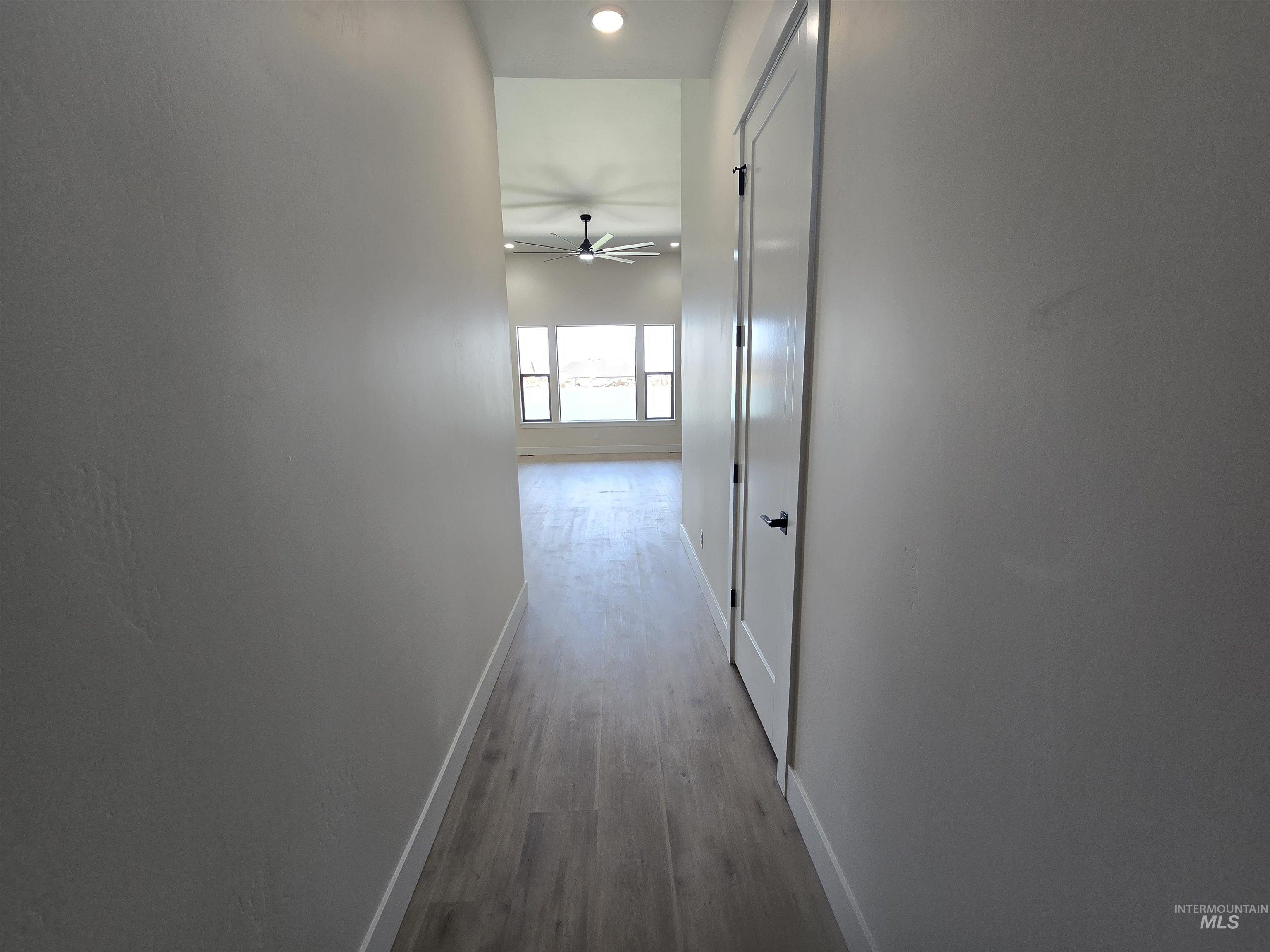 Hall with baseboards and wood finished floors