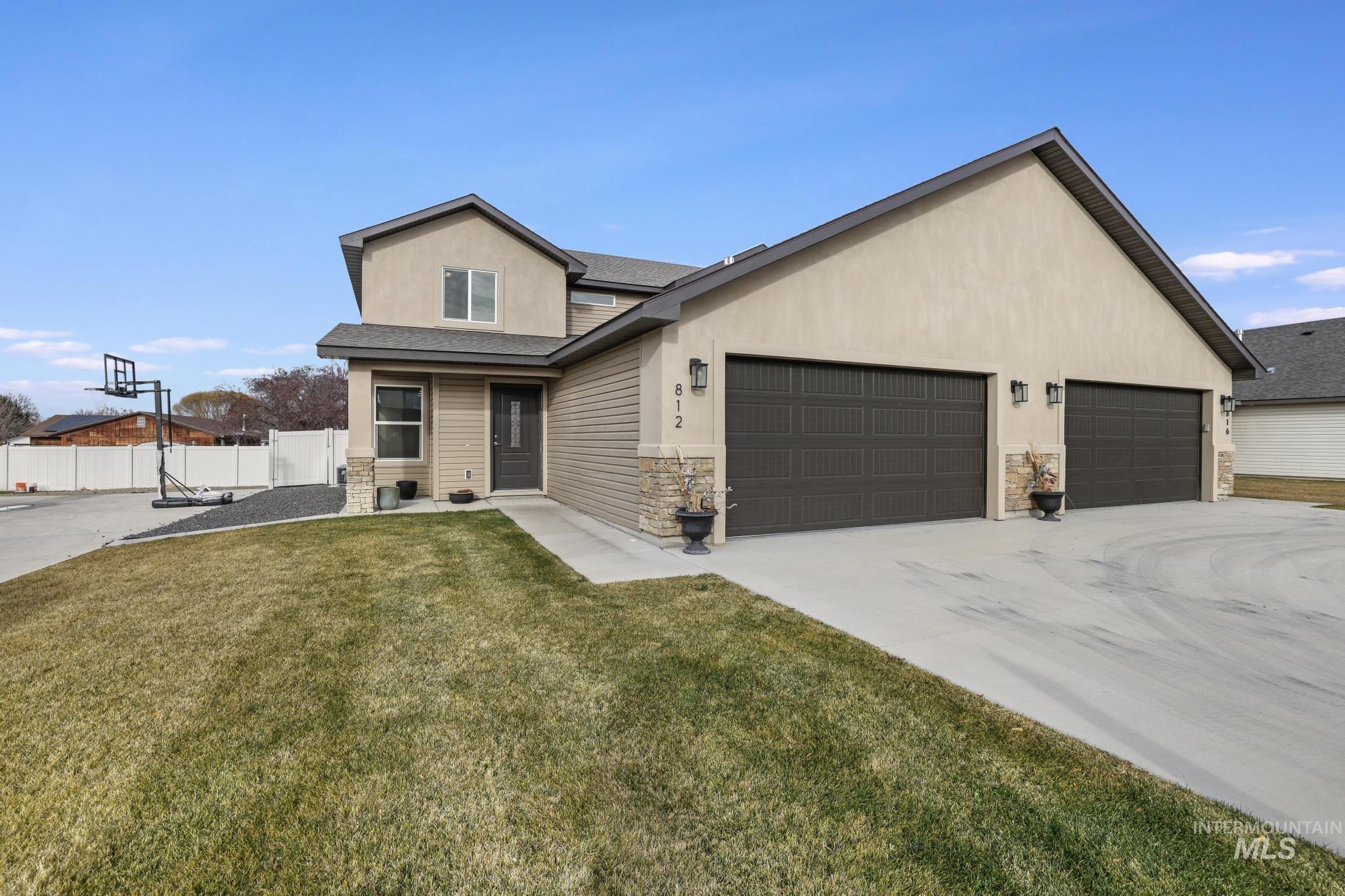 View of front of house featuring a shingled roof, stone siding, stucco siding, and concrete driveway