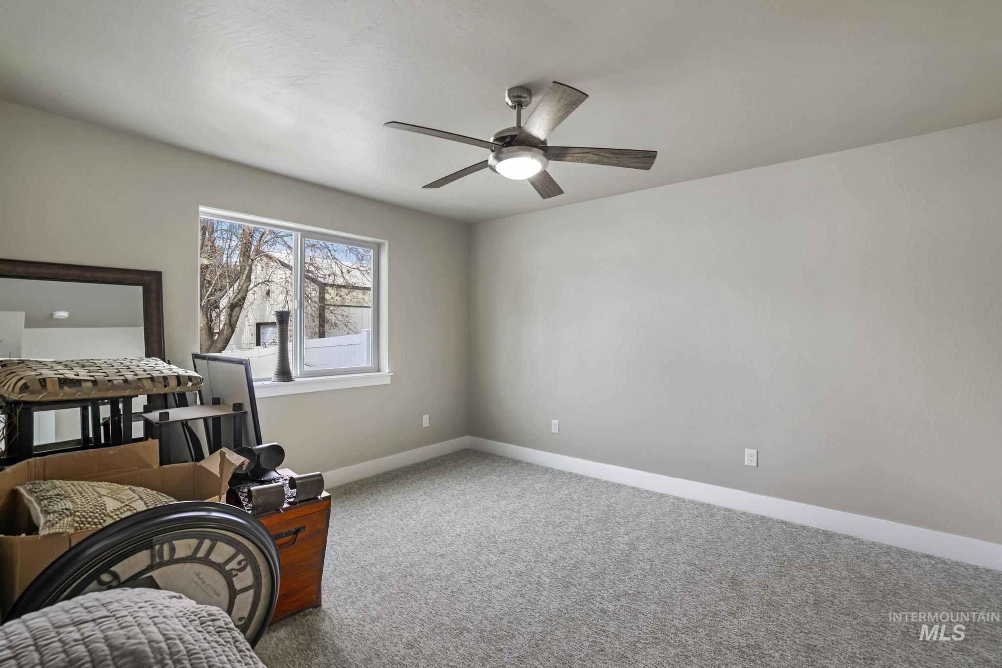 Bedroom with a ceiling fan and carpet