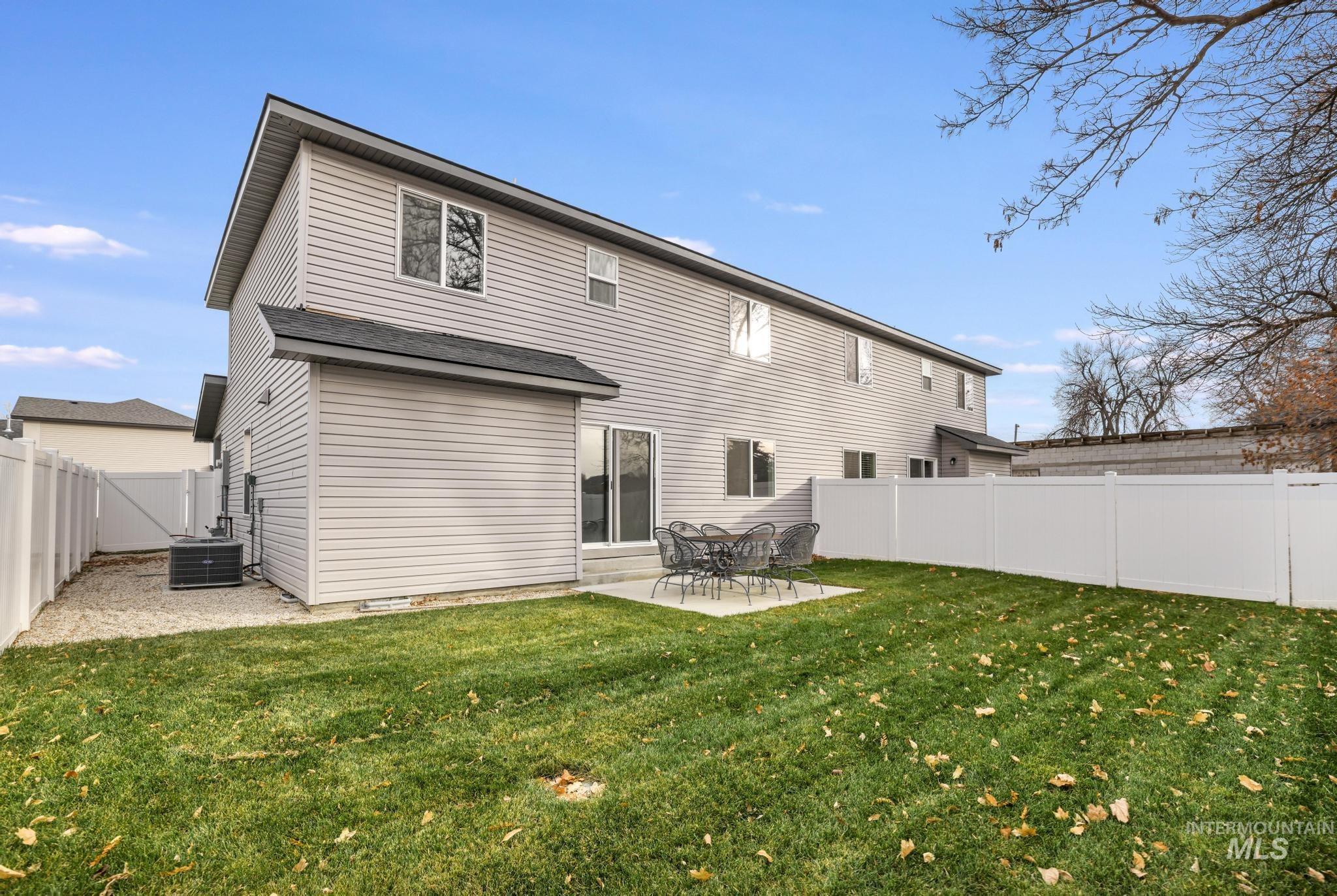 Rear view of house featuring a patio area and a fenced backyard