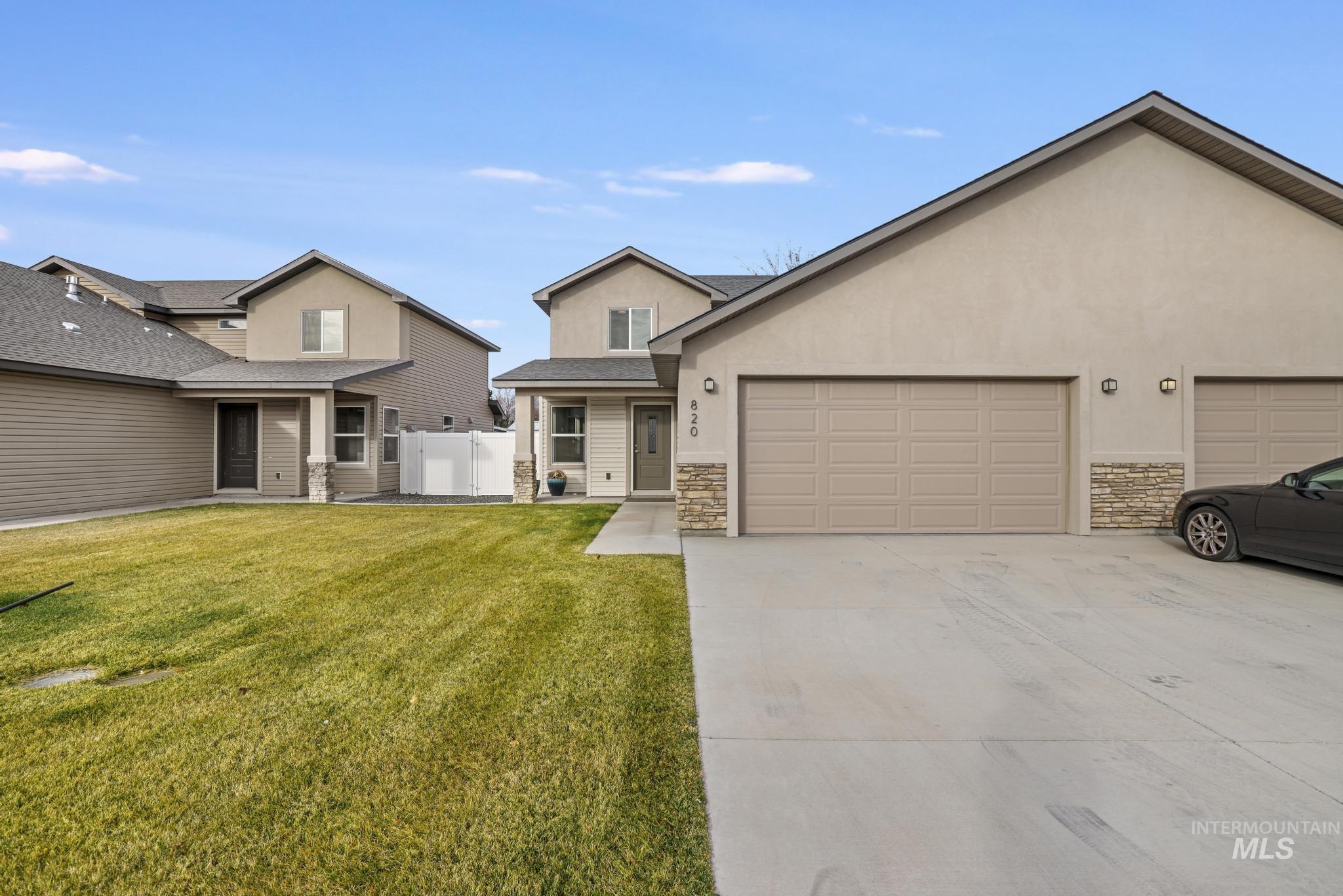 Traditional-style house with stone siding, stucco siding, concrete driveway, and an attached garage