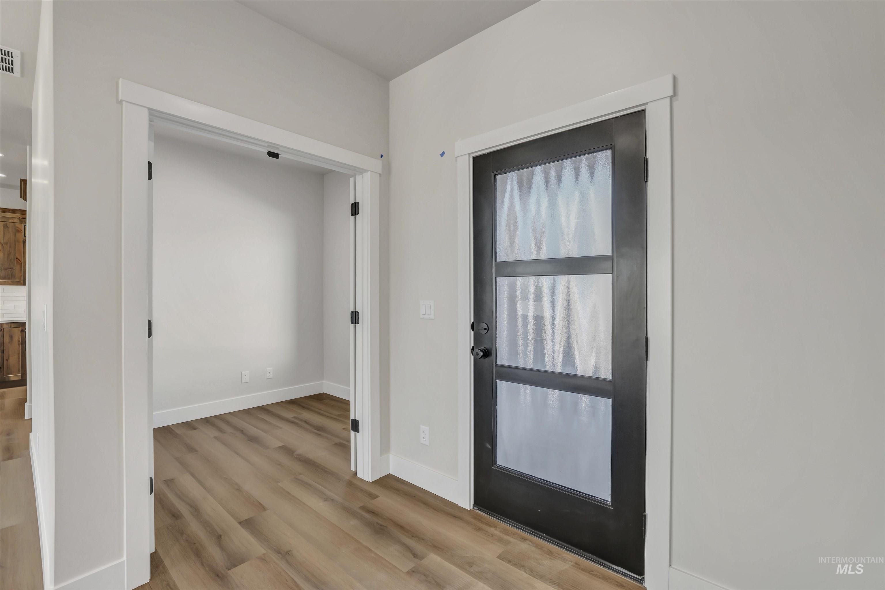 Foyer featuring wood finished floors and baseboards