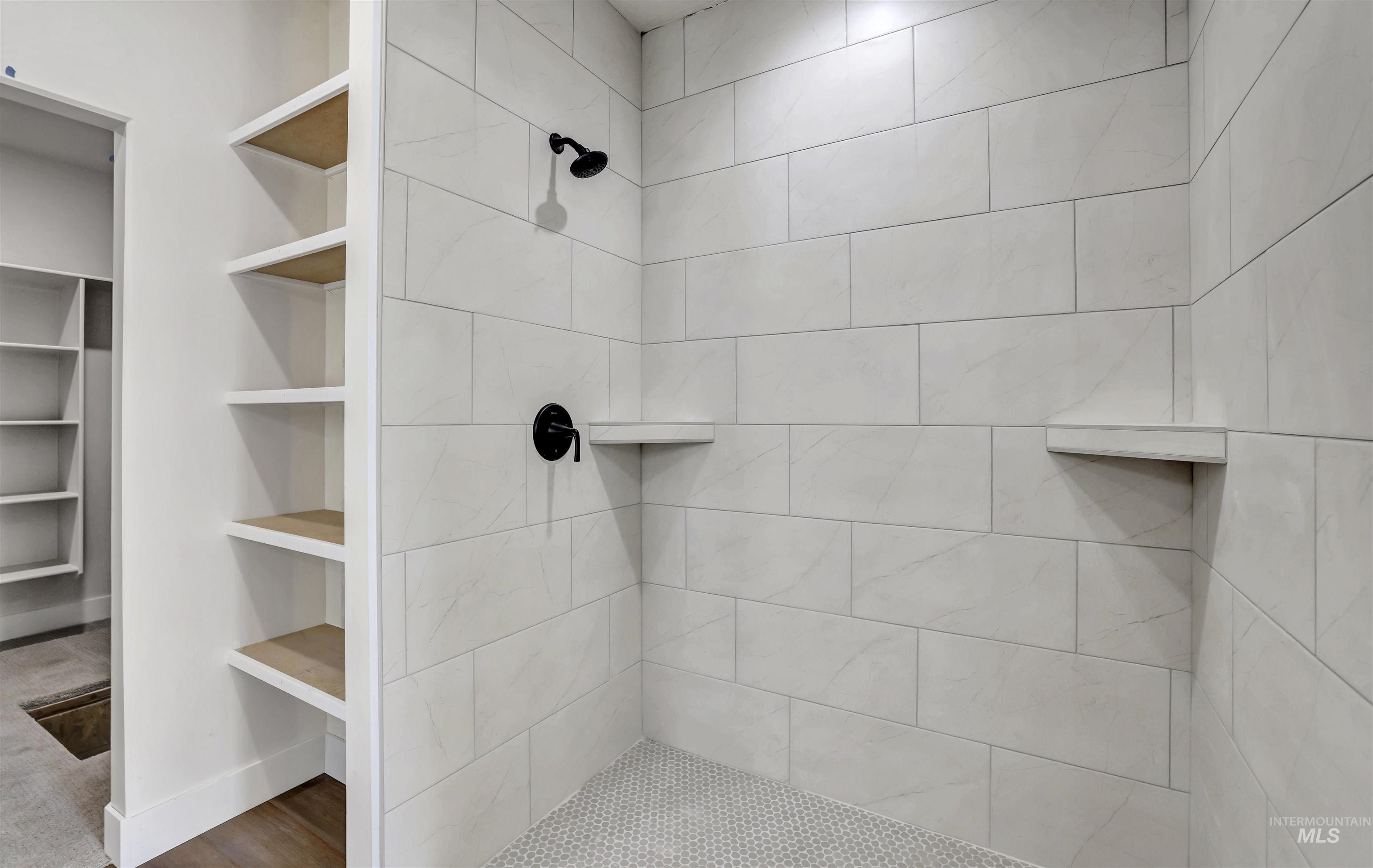 Full bathroom with a tile shower and a walk in closet