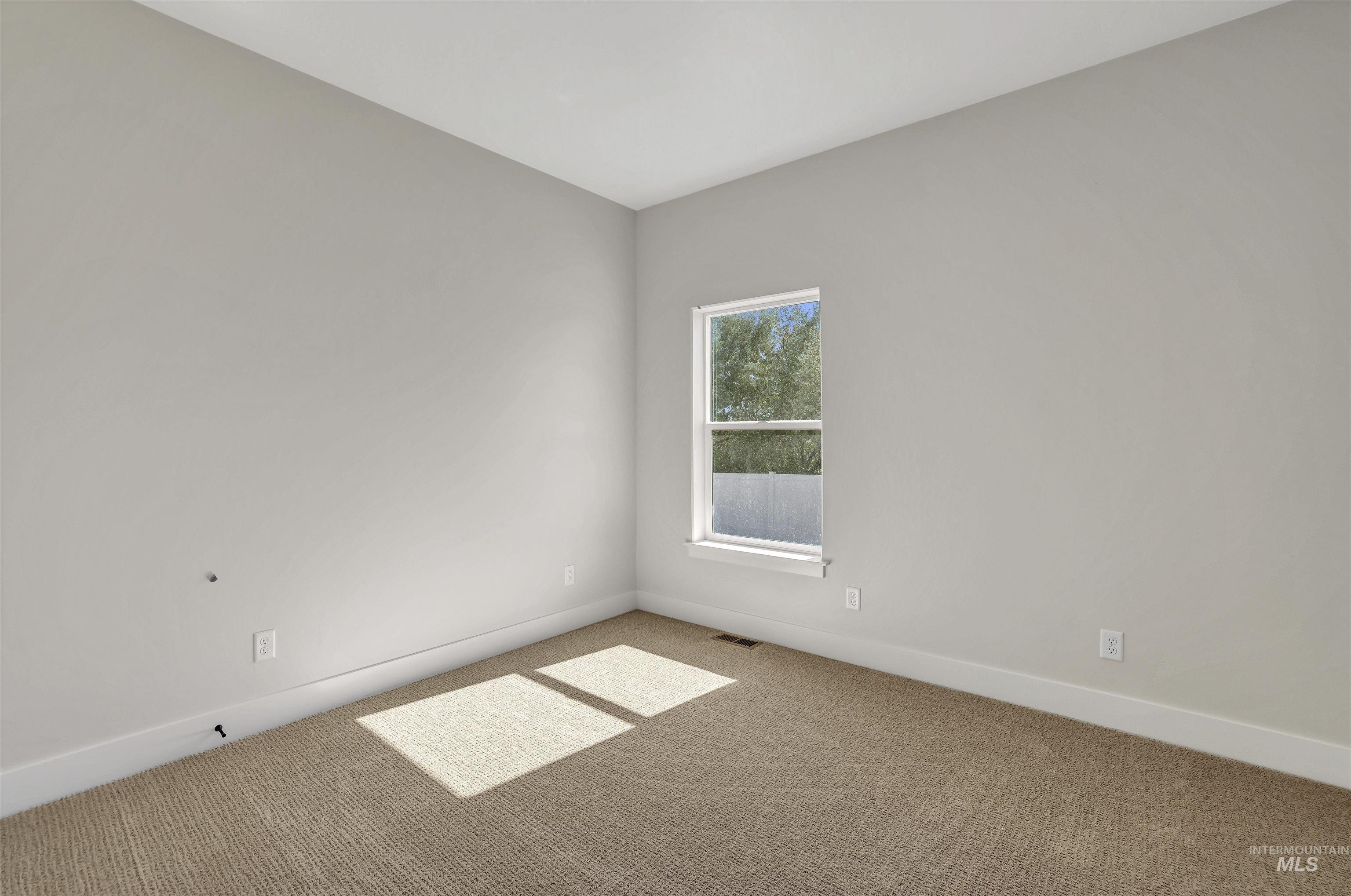 Carpeted empty room with baseboards