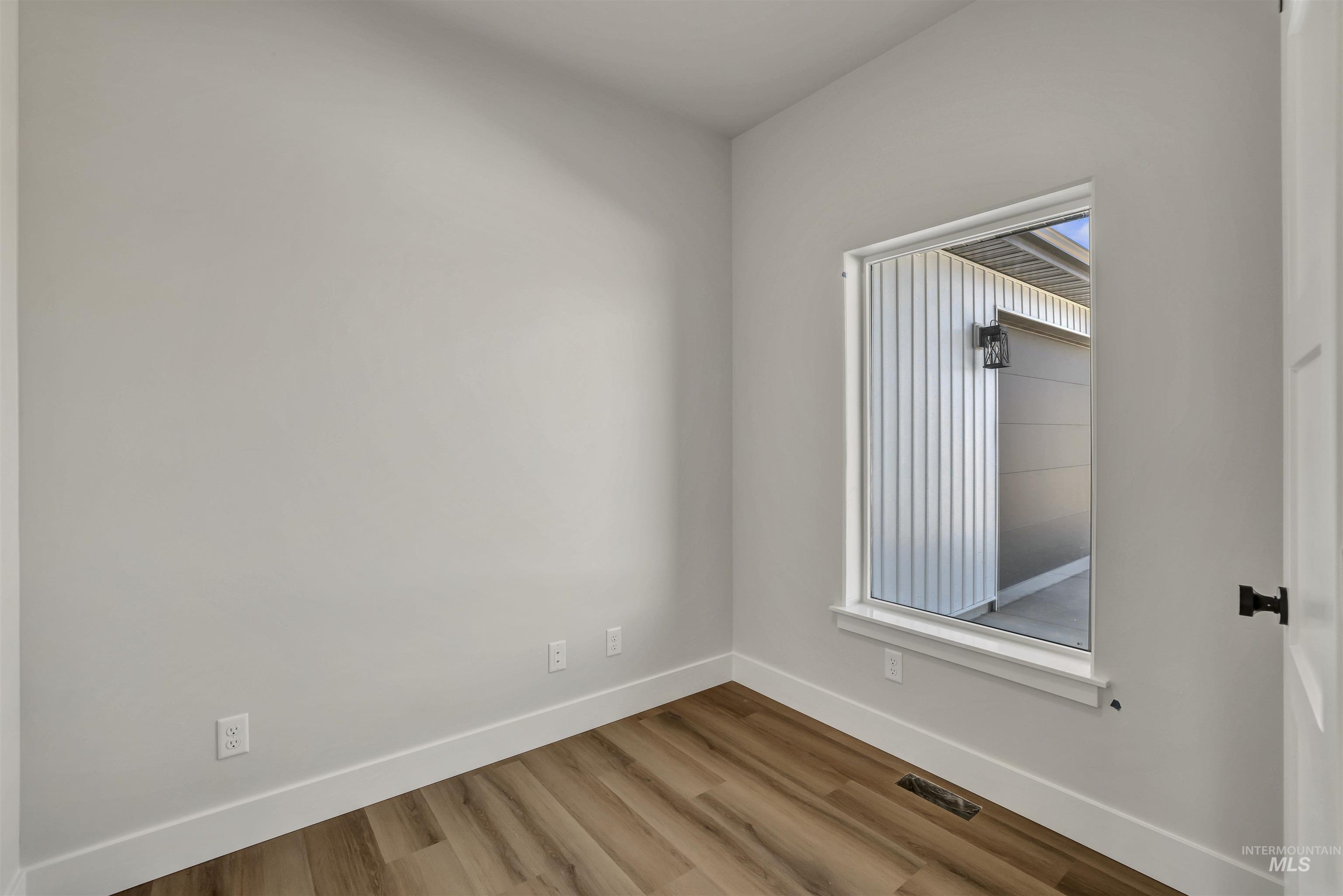 Unfurnished room featuring baseboards and wood finished floors