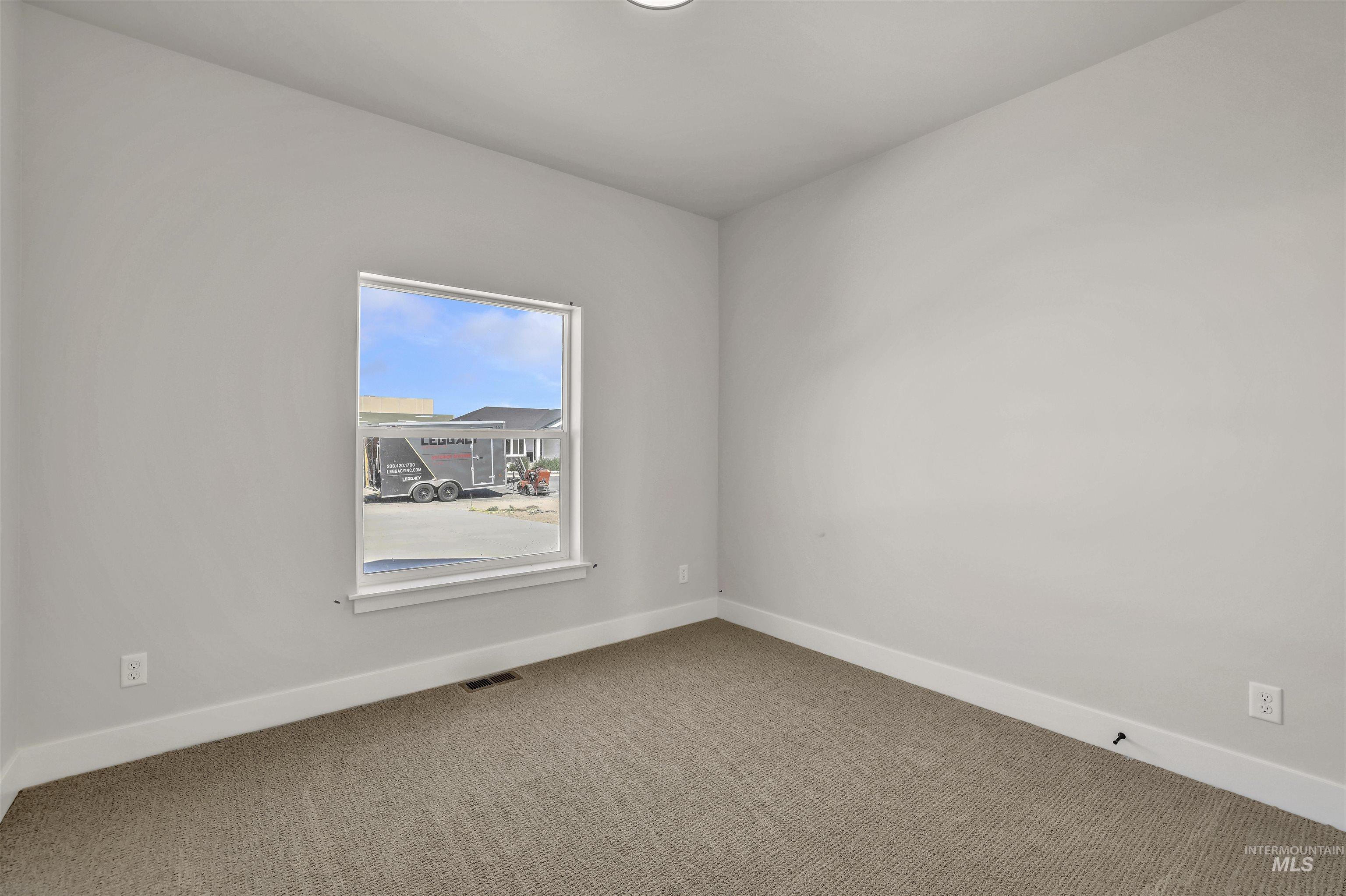 Empty room featuring carpet flooring and baseboards