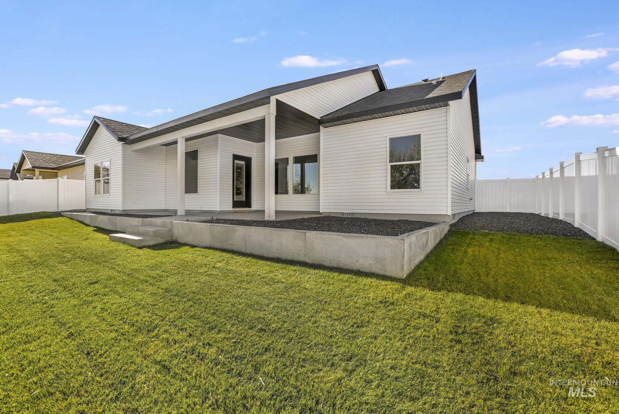 Rear view of house with a fenced backyard, a patio area, and a shingled roof