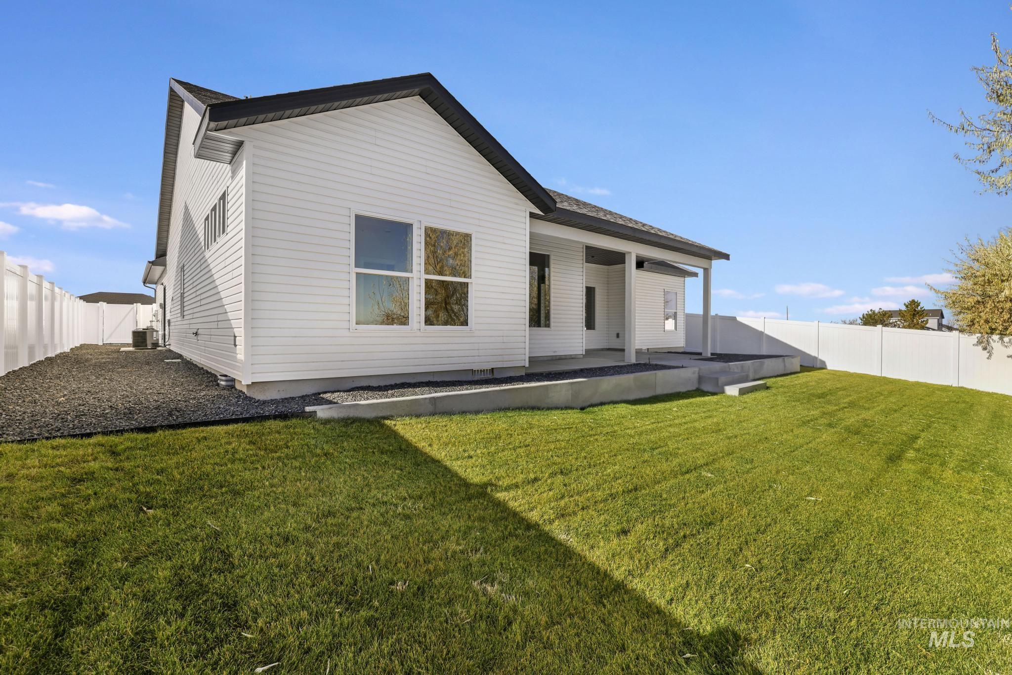 Back of house with a fenced backyard and a patio