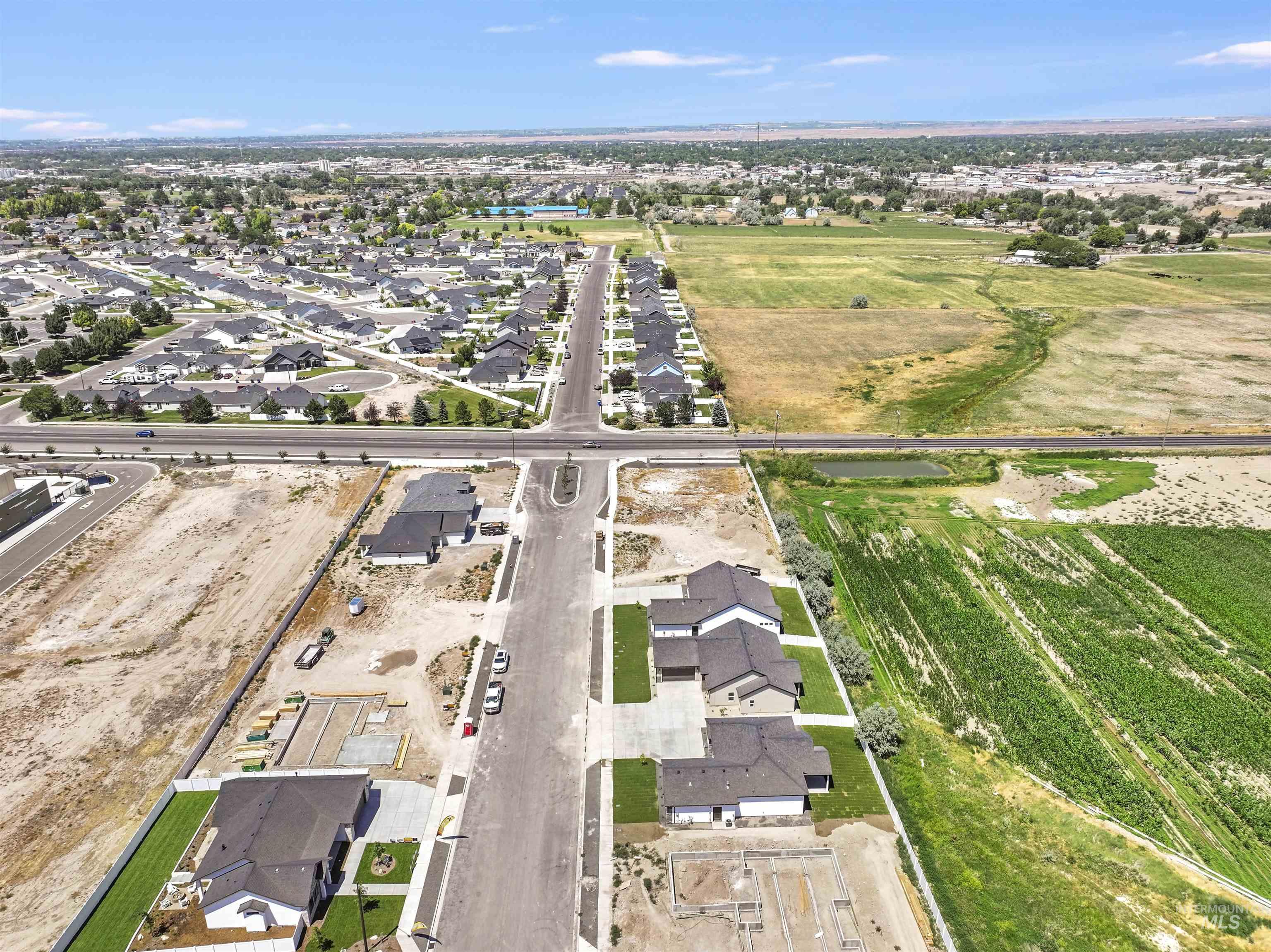 Aerial view of property and surrounding area with nearby suburban area
