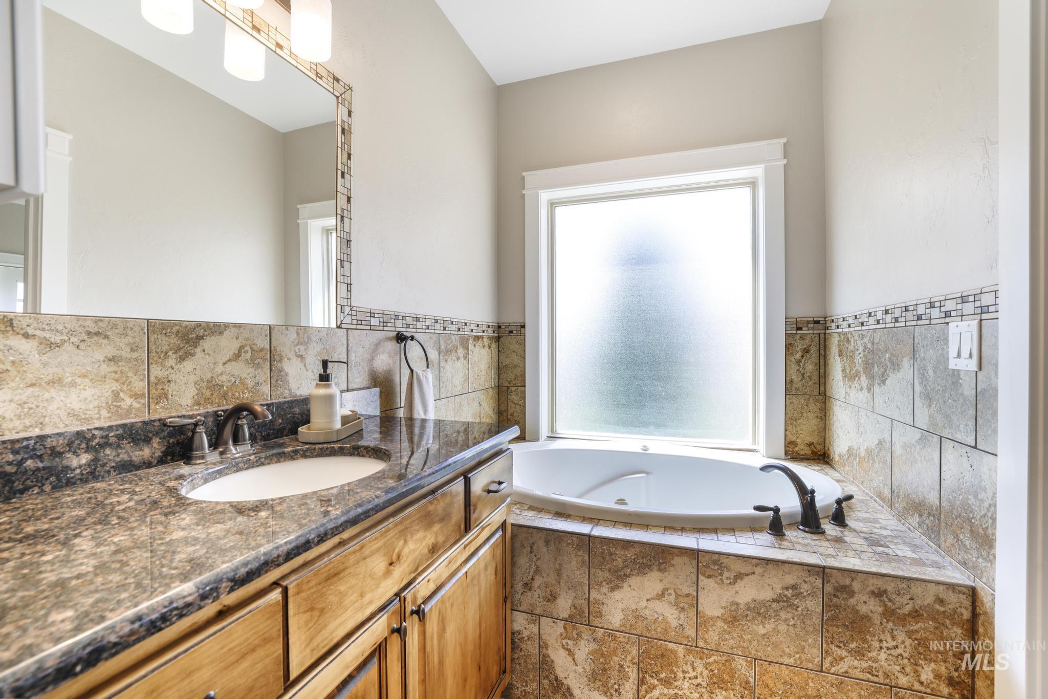 Full bath featuring vanity and a jetted tub