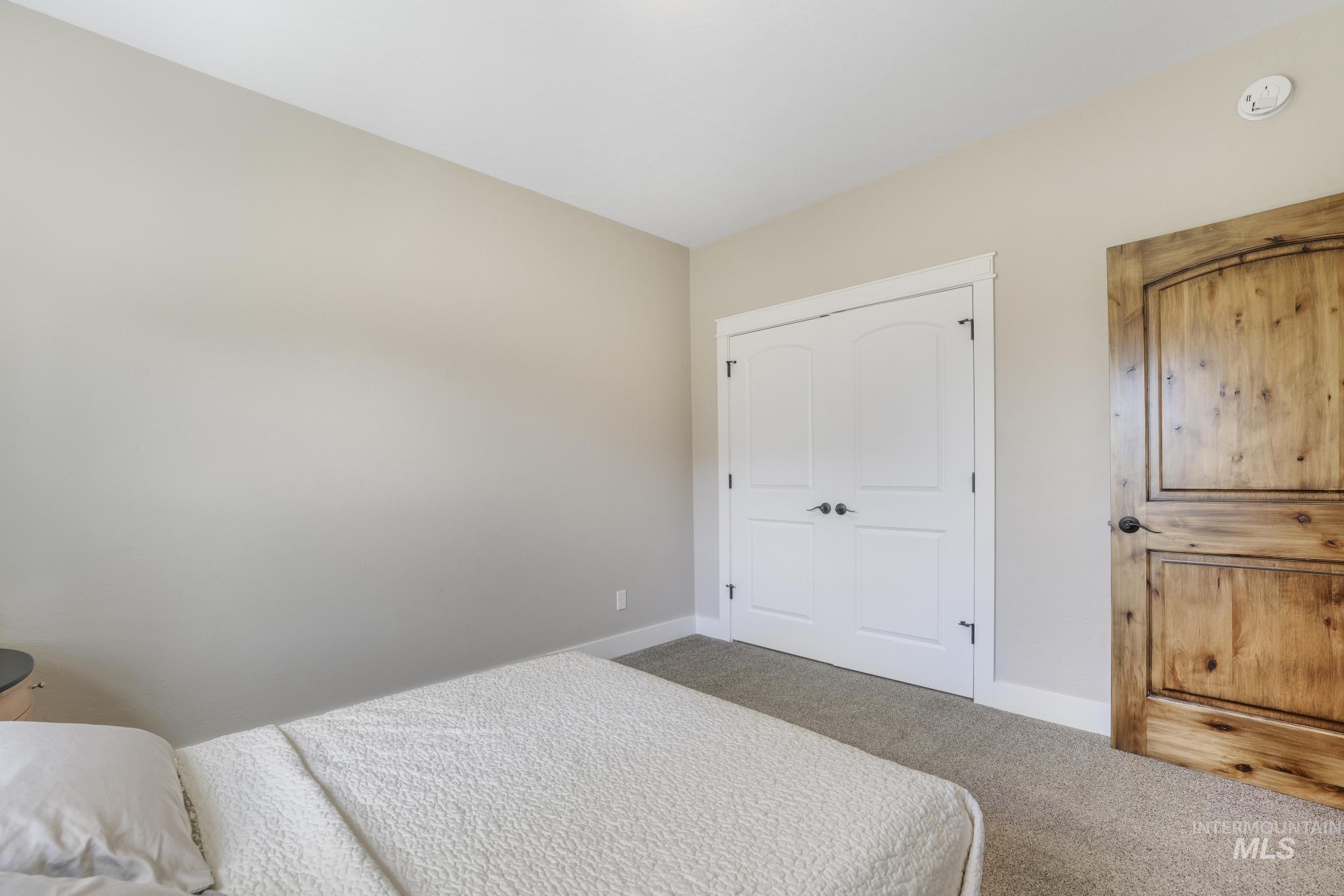 Carpeted bedroom featuring baseboards and a closet