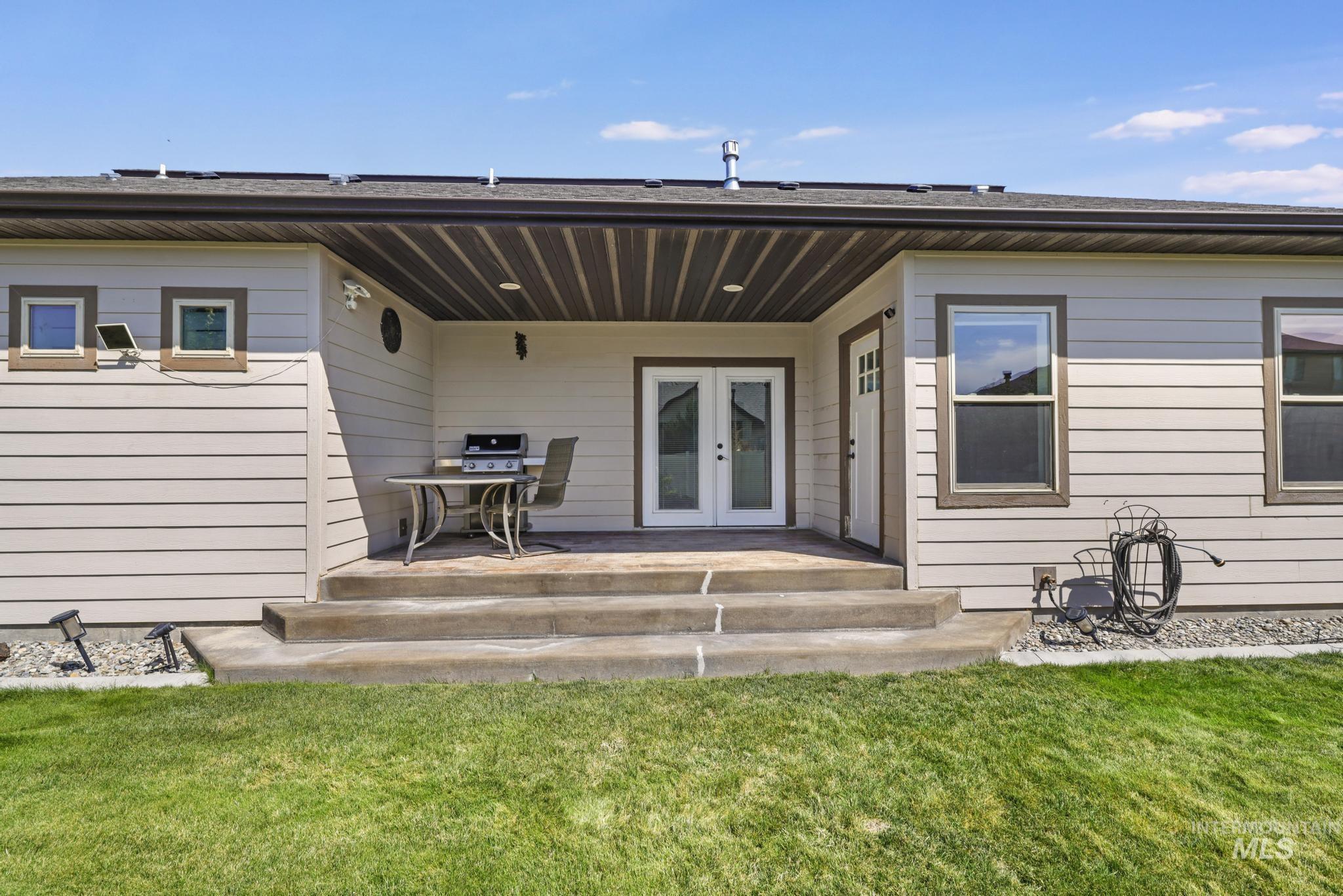 Back of house featuring french doors, a patio area, and a yard