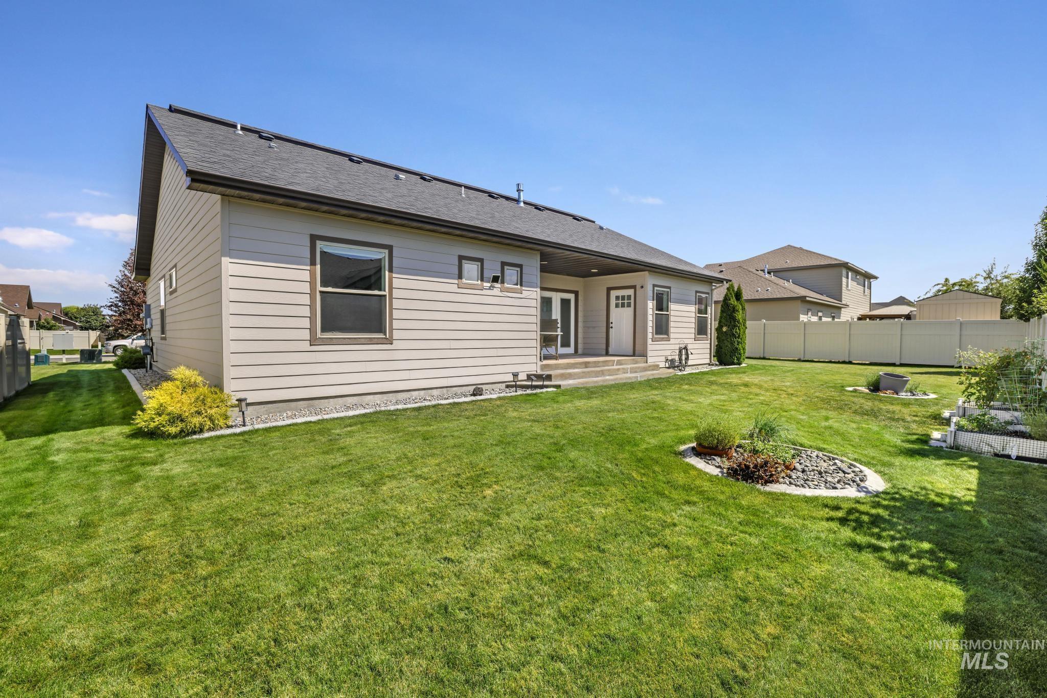 Back of house featuring a shingled roof and a patio area