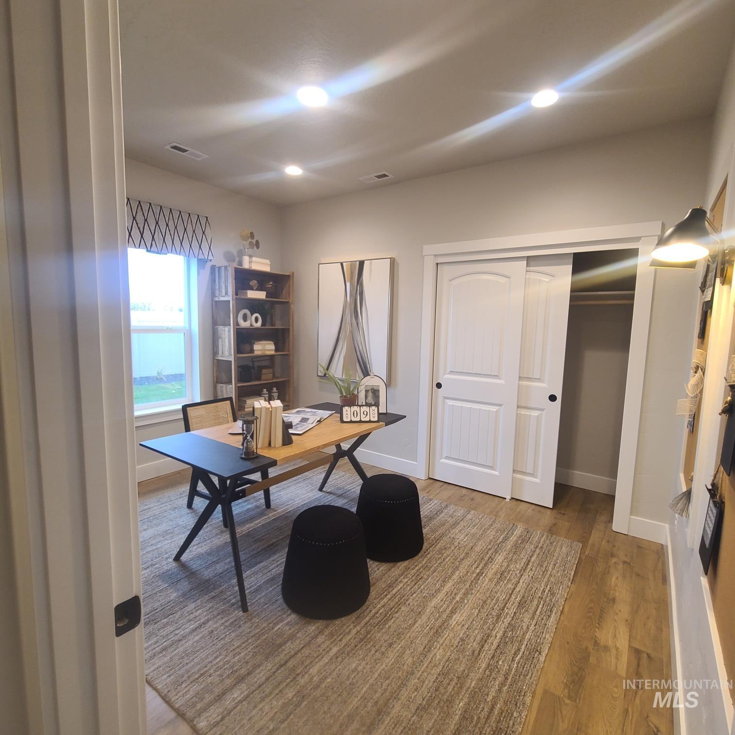 Office space with wood finished floors and recessed lighting