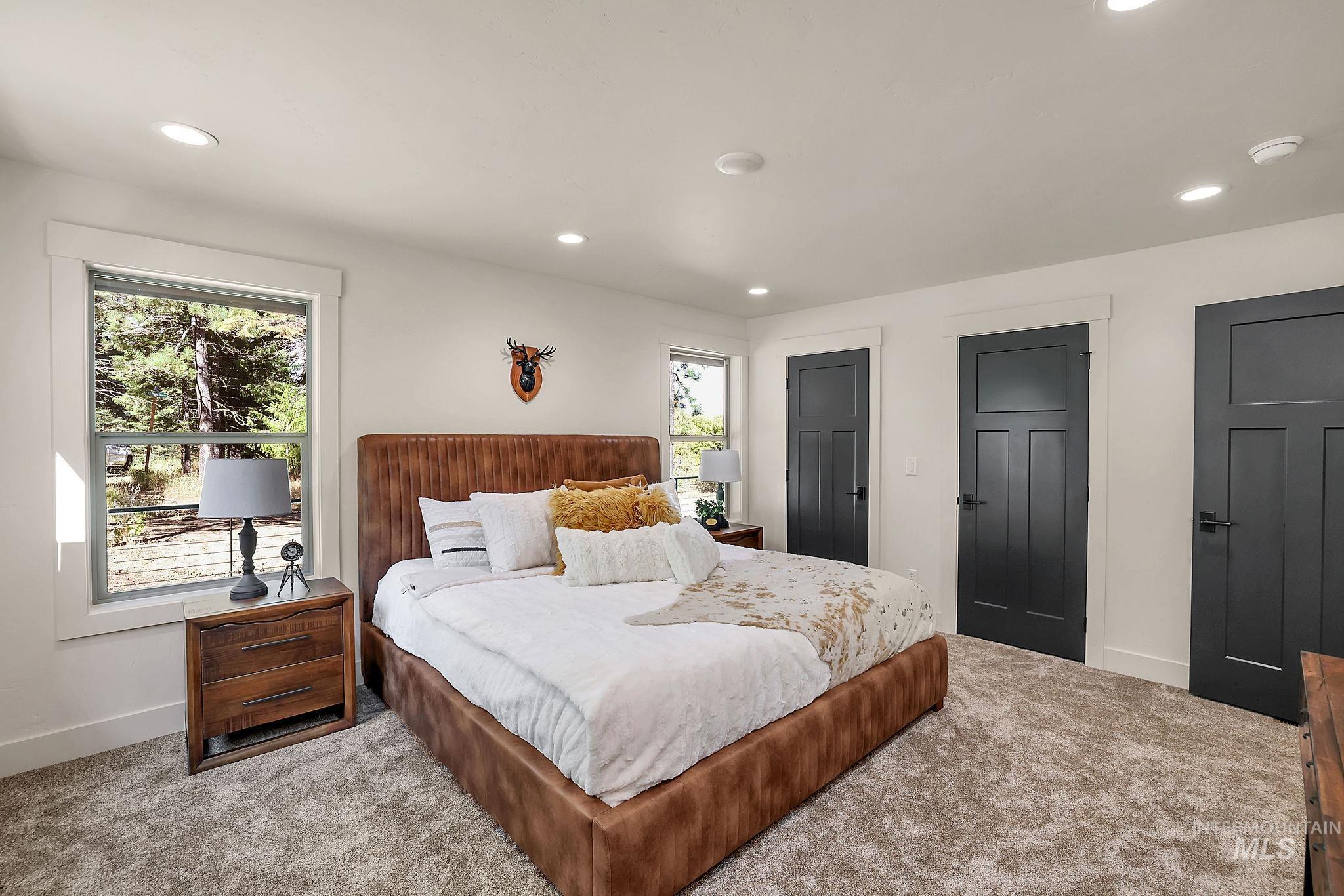 Carpeted bedroom featuring recessed lighting and two closets