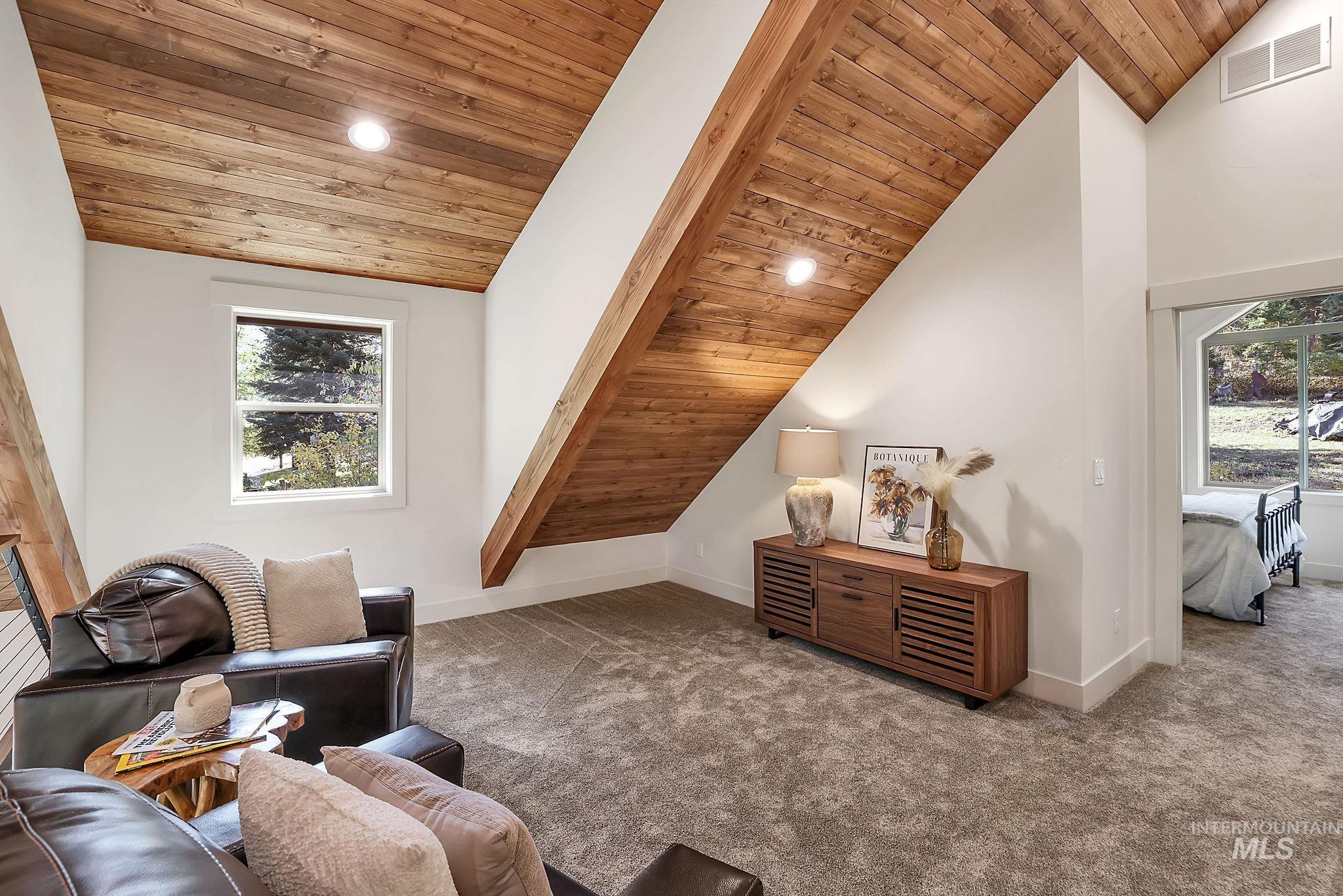 Carpeted living area with wood ceiling, vaulted ceiling, recessed lighting, and plenty of natural light