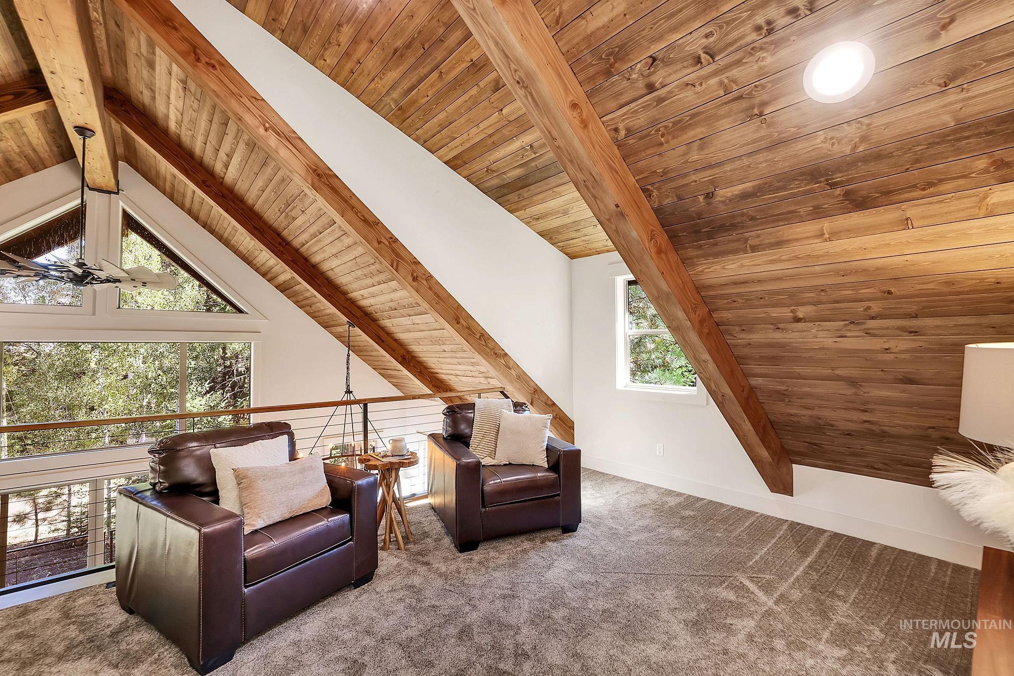 Sitting room with wood ceiling, an upstairs landing, and carpet