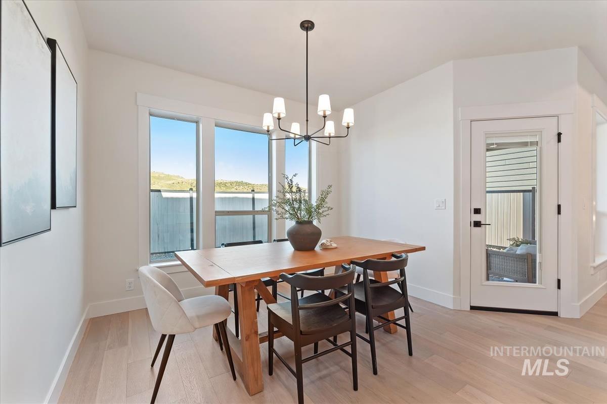 Dining space featuring light wood-type flooring and a chandelier
